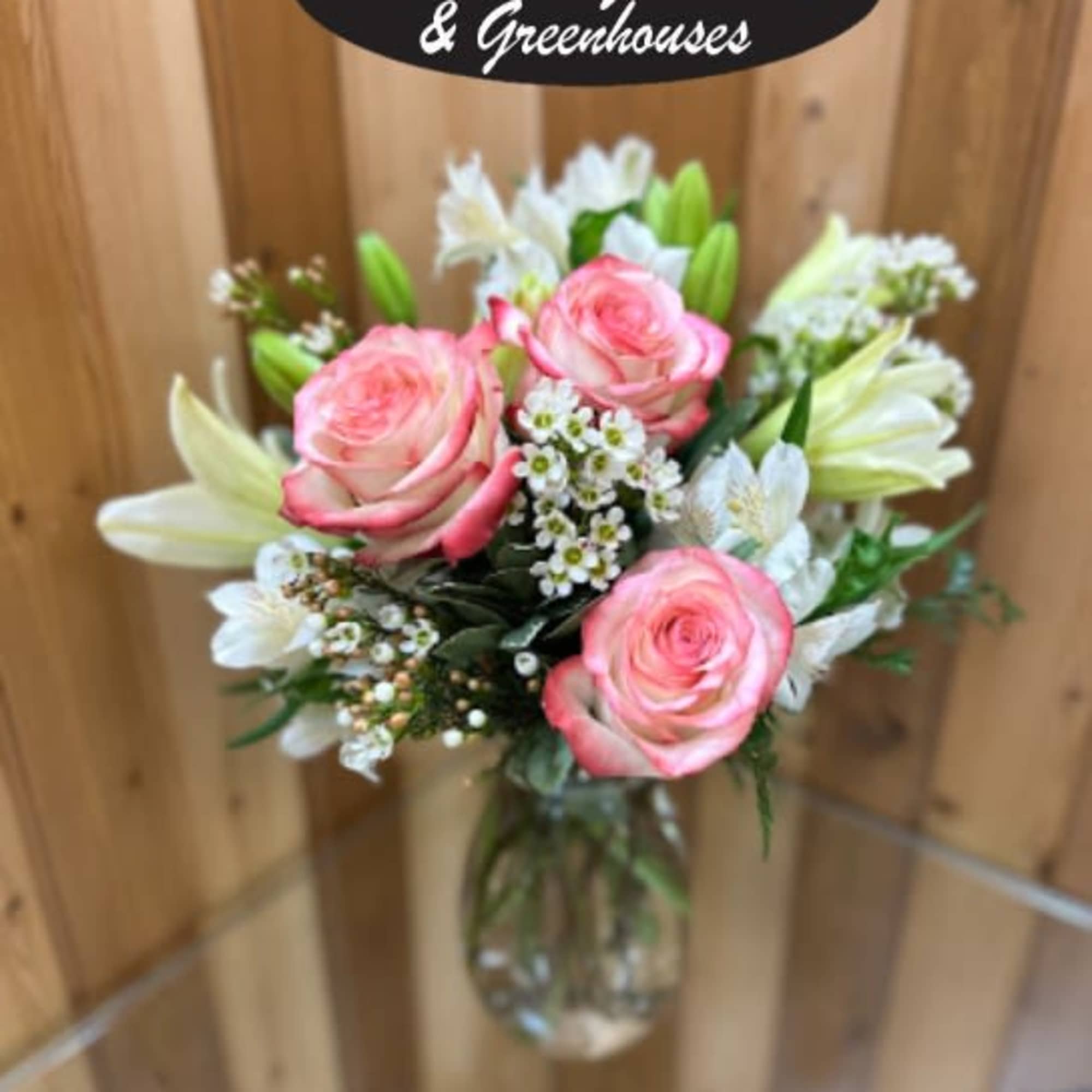 Pink roses and white lilies in a clear glass vase