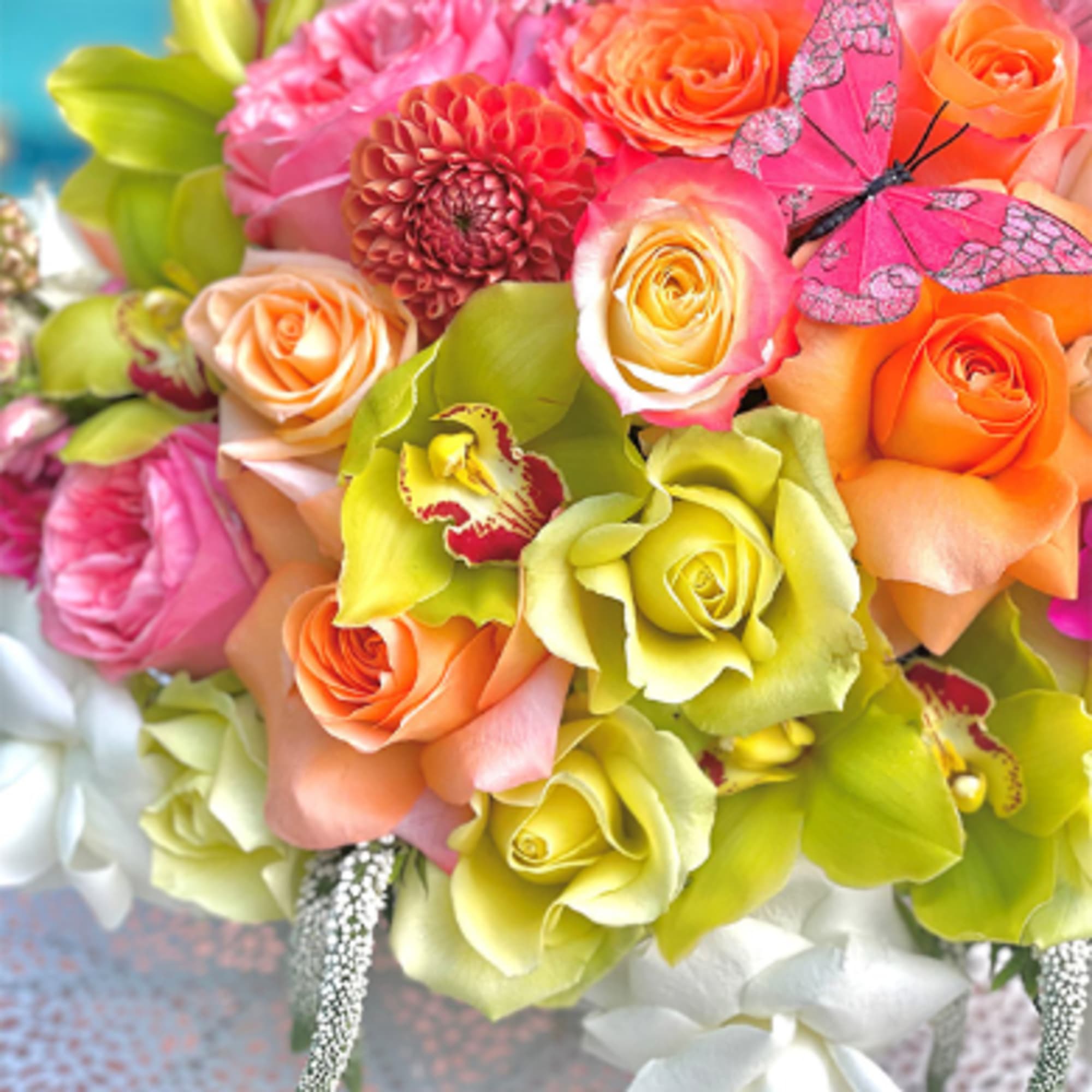 Colorful bouquet of roses, orchids, and a dahlia with butterfly accents