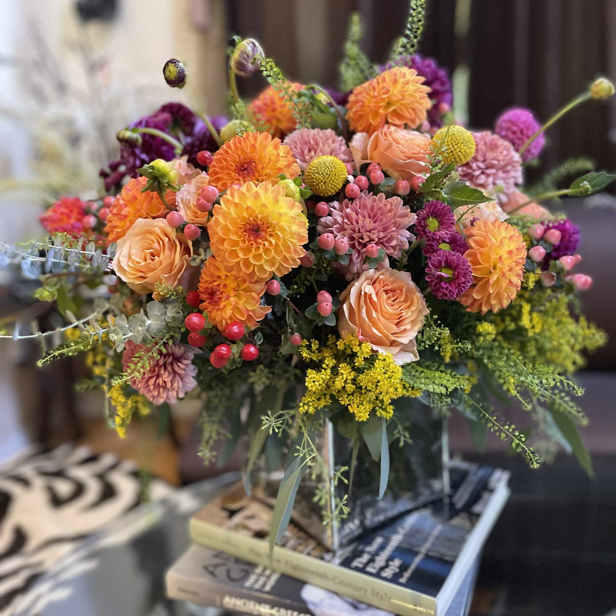 Colorful bouquet of orange, pink, and purple flowers in a glass vase
