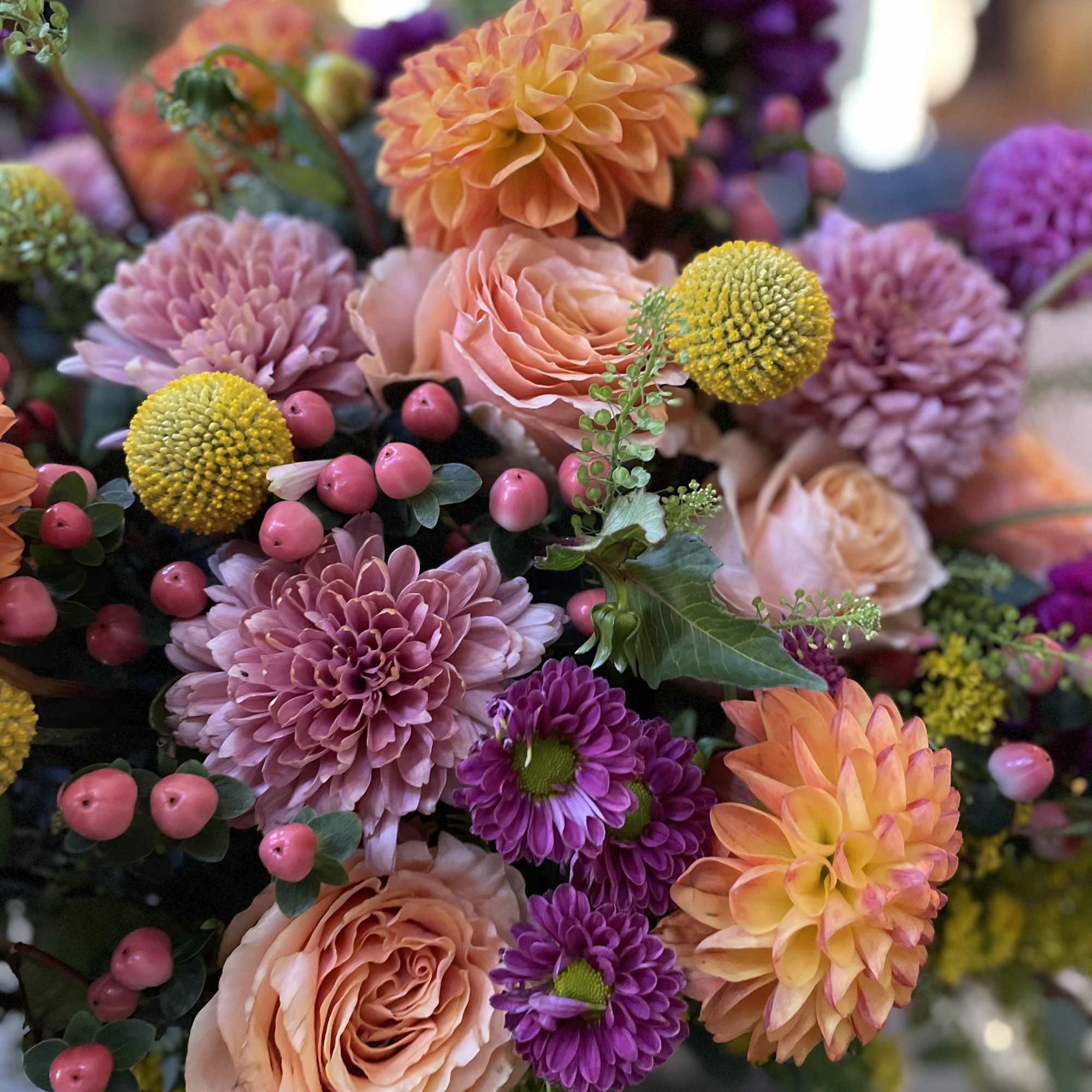 Bouquet of peach, purple, and pink flowers with yellow accents