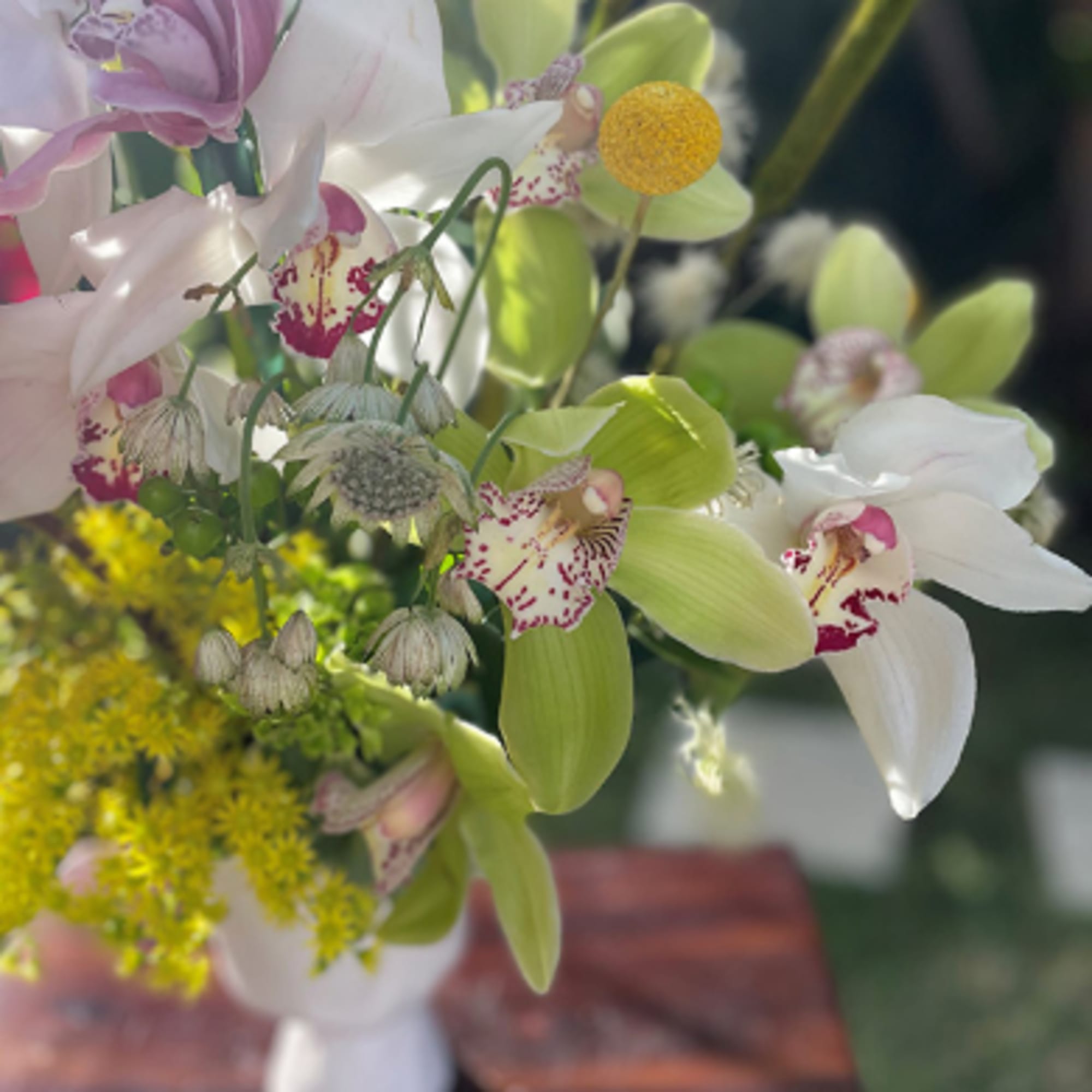 Bouquet of white and pink orchids with yellow filler flowers