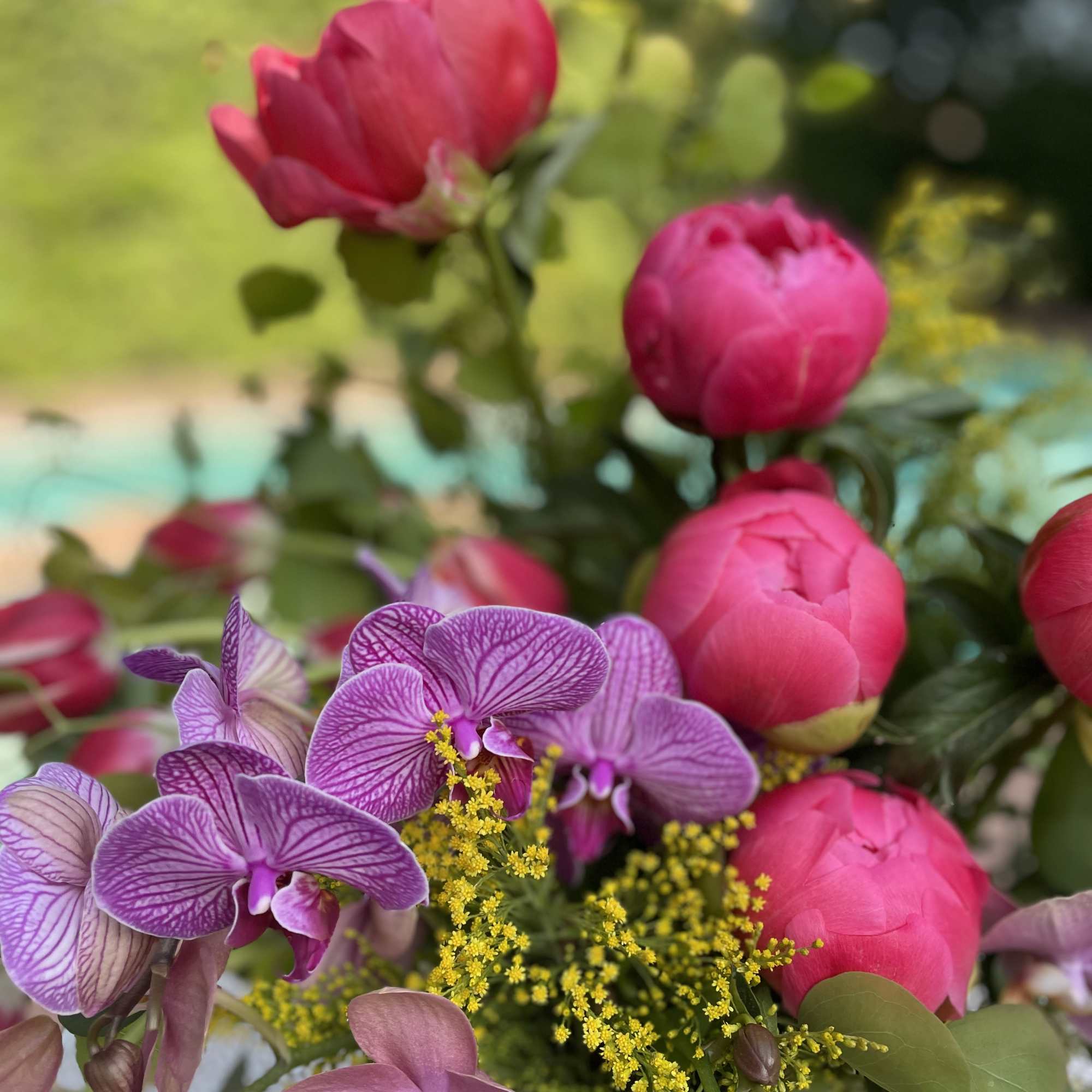 Pink peonies and purple orchids with yellow filler flowers