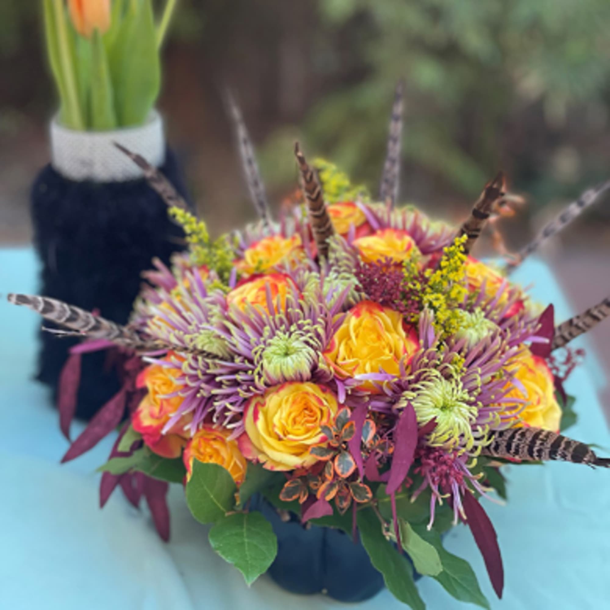 Bouquet of yellow roses and purple chrysanthemums with feather accents