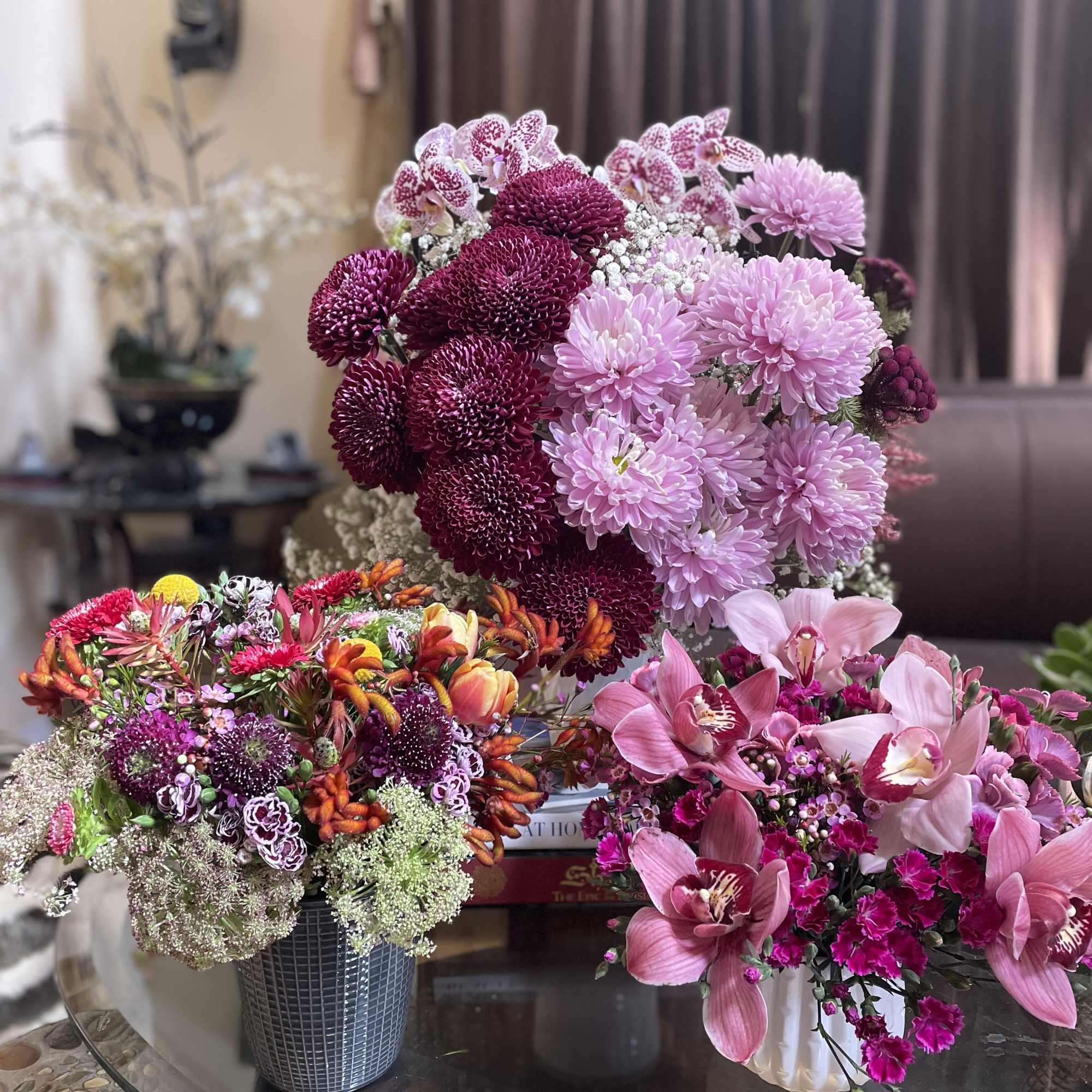 Three floral arrangements with pink and purple blooms on a table
