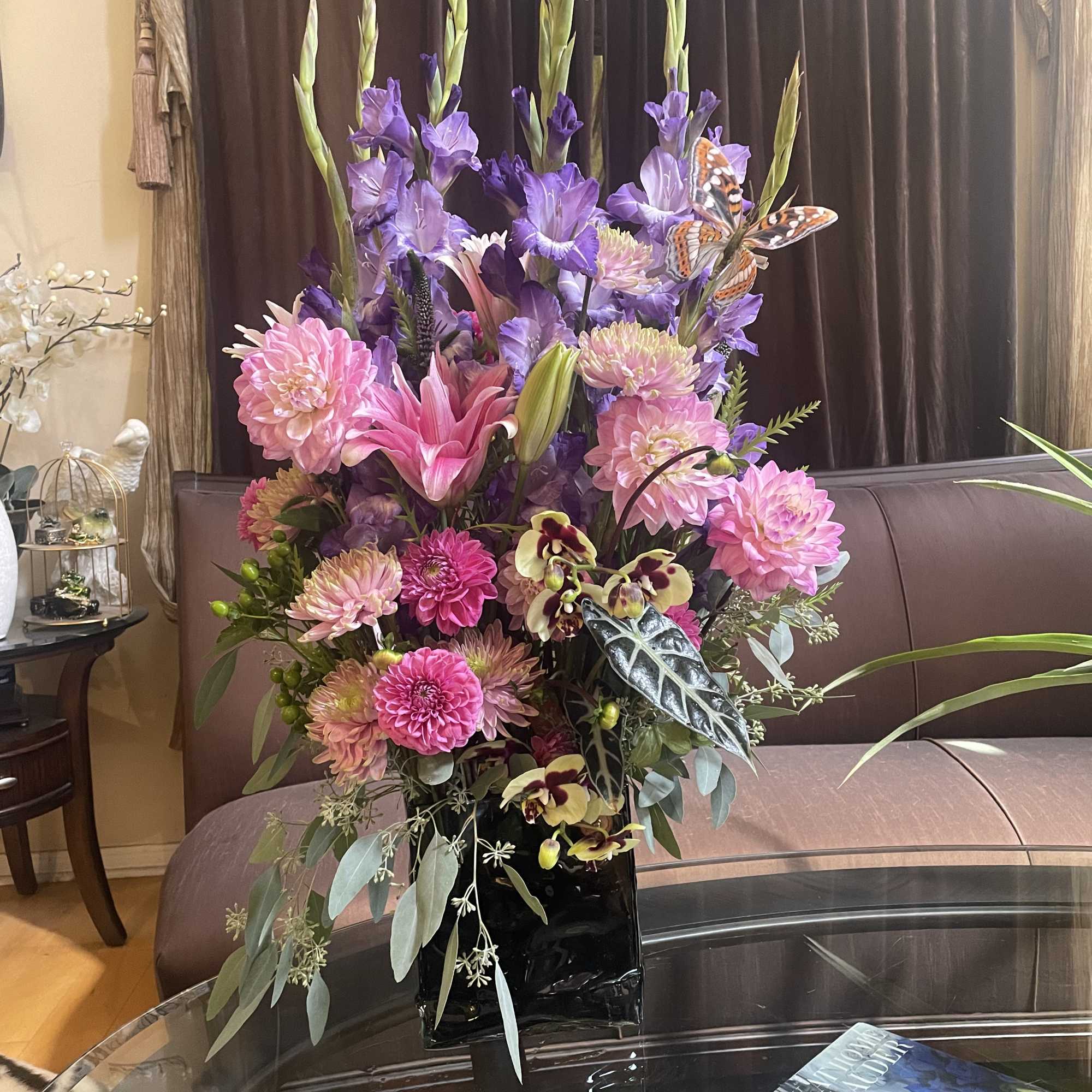 Tall bouquet of pink and purple flowers in a black vase