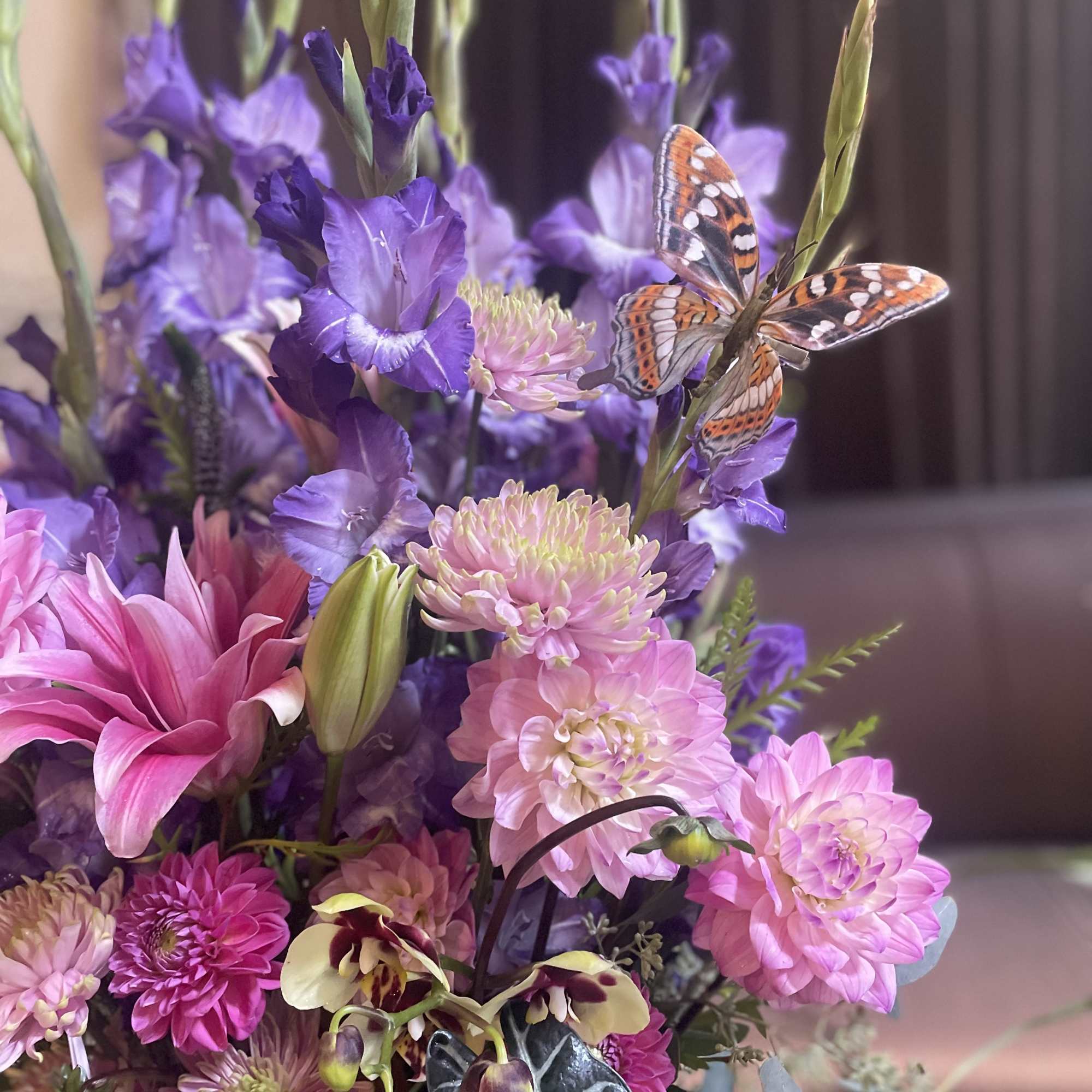 Purple and pink mixed bouquet with a butterfly accent