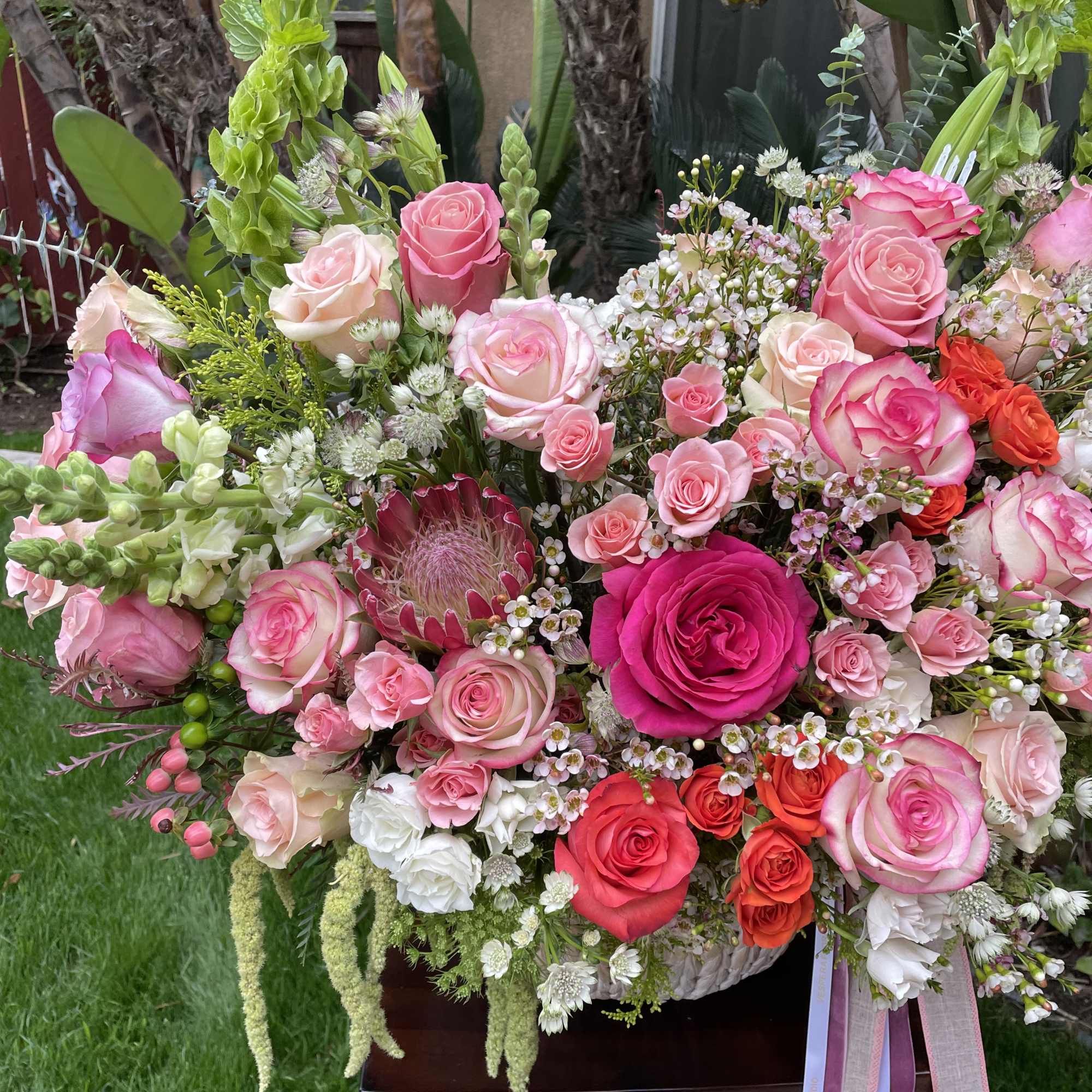 Large bouquet of pink and white roses with mixed blooms and ribbons