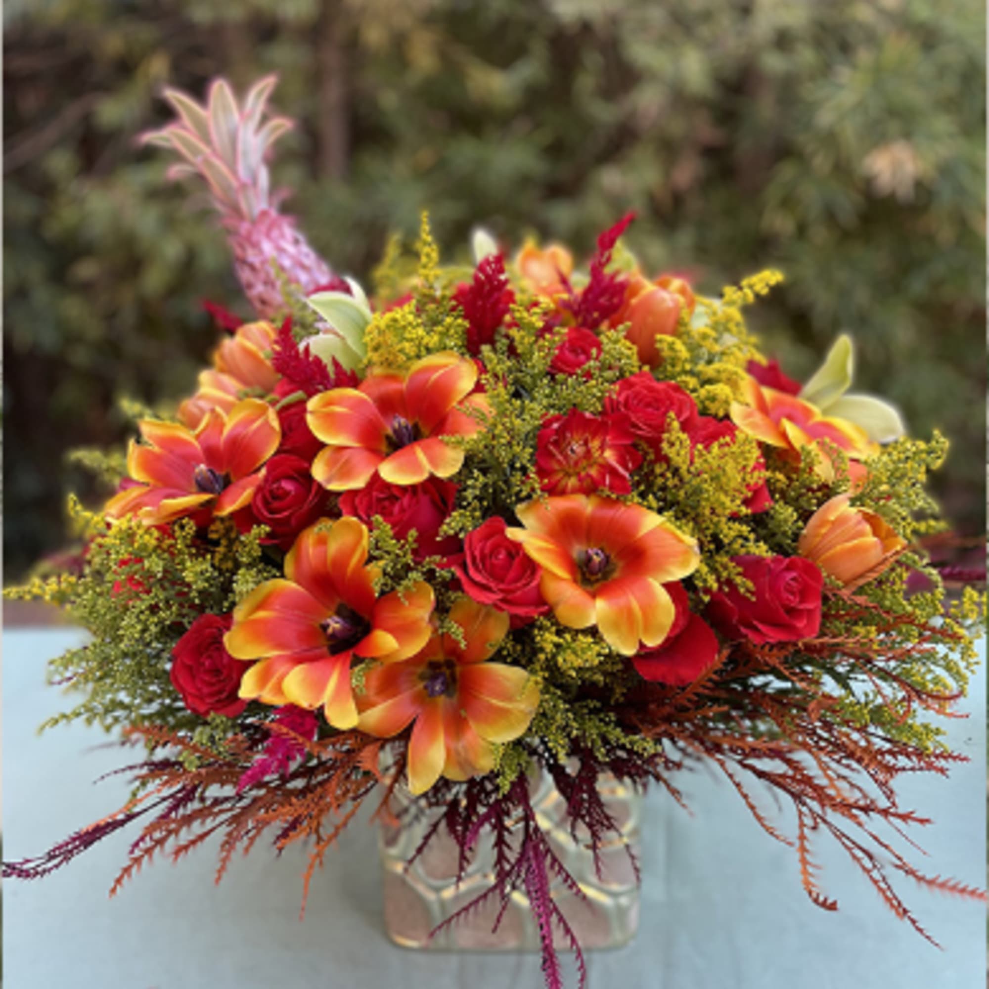 Bouquet of orange tulips and red roses in a clear vase