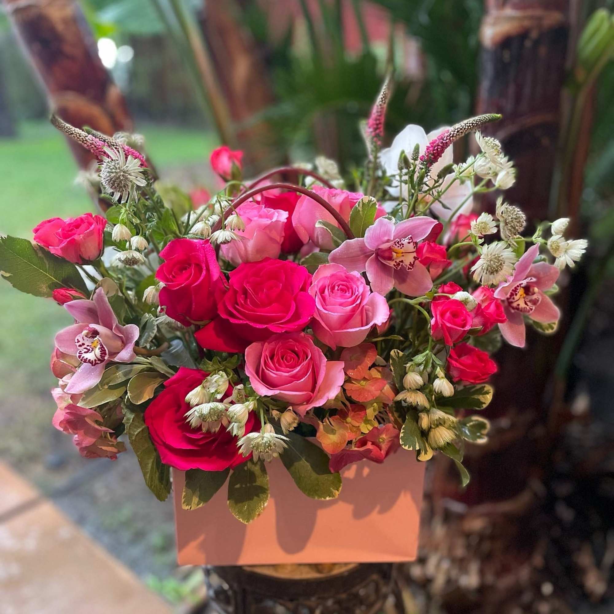 Pink and red rose bouquet with pale orchids in a pink box