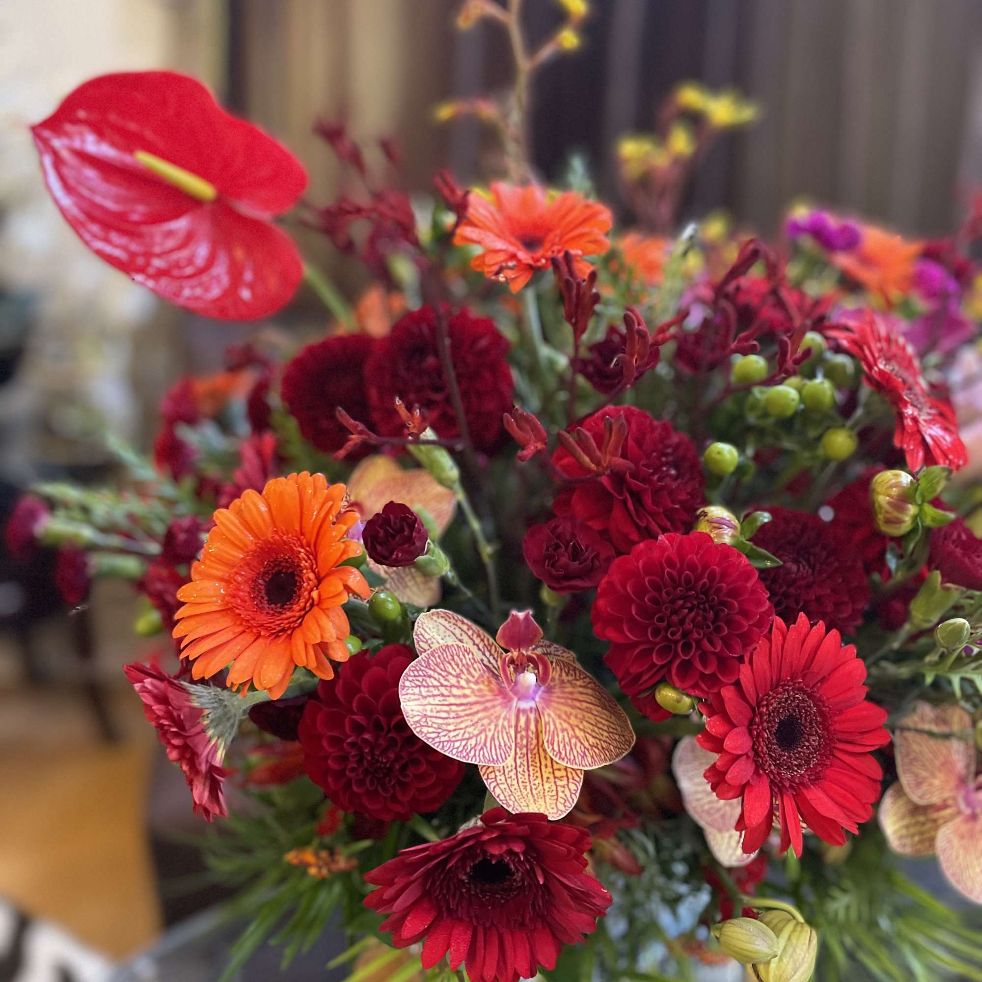 Mixed bouquet with red and orange blooms in a vase