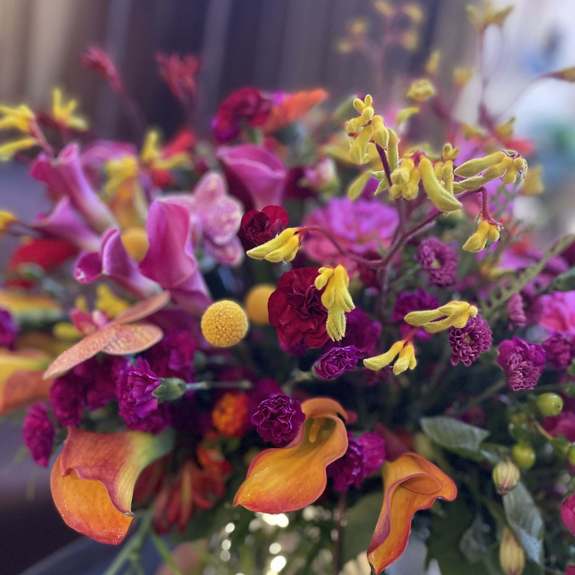 Colorful bouquet with calla lilies, orchids, and small round blooms