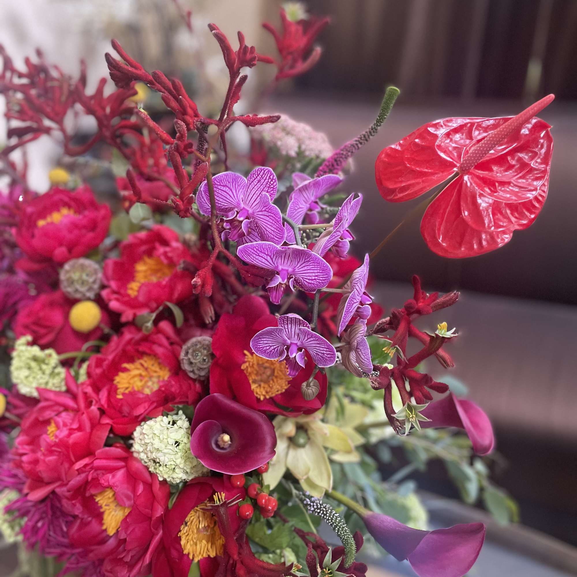 Bright pink floral arrangement with purple orchids and red anthuriums