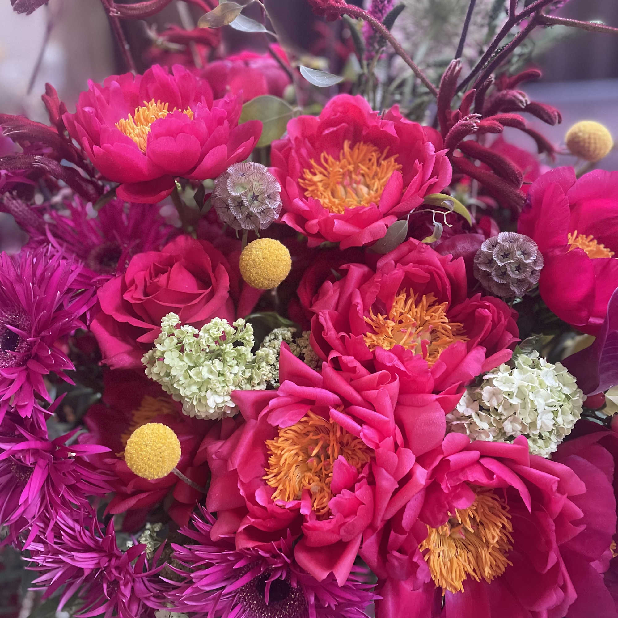 Bright pink bouquet with orange-centered blooms and small white accents