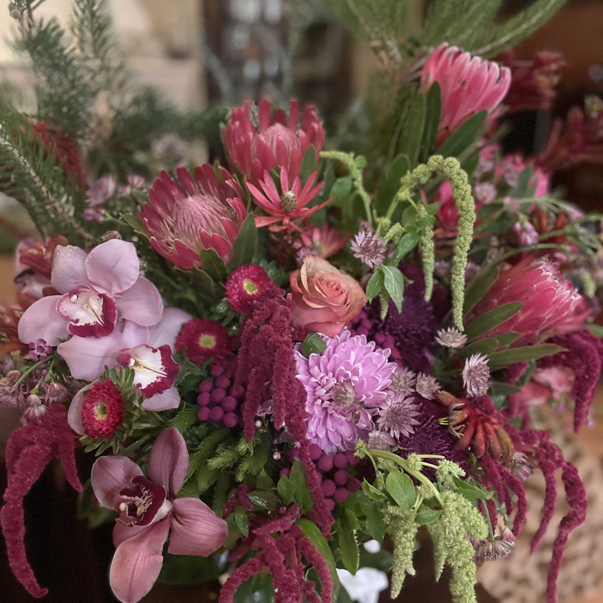 Pink and purple mixed bouquet with orchids, protea, and chrysanthemums