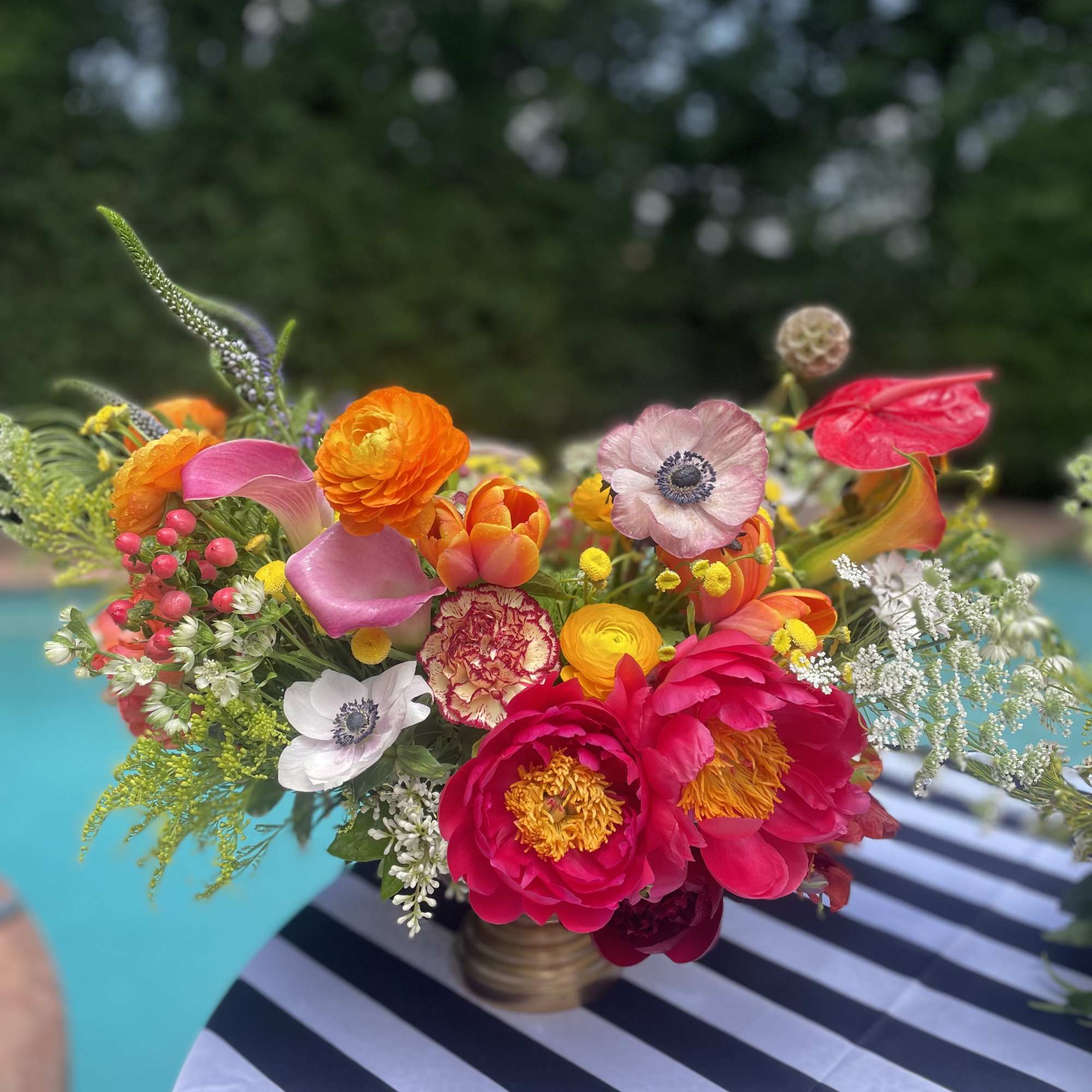 Bright mixed bouquet with pink, orange, yellow, and white flowers in a small vase