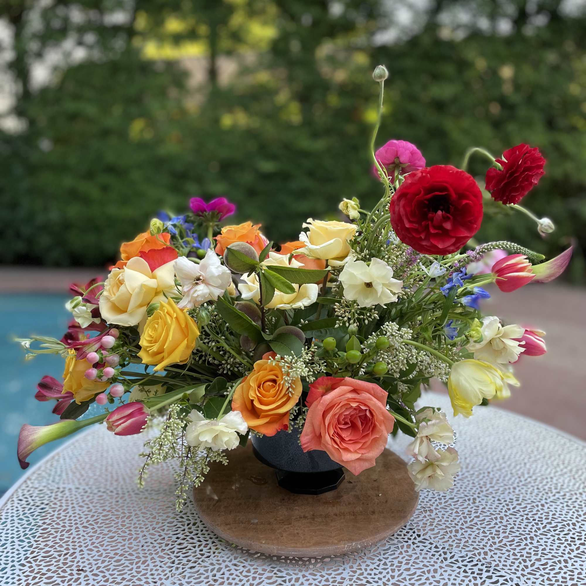 Colorful mixed flower arrangement in a low vase on a table