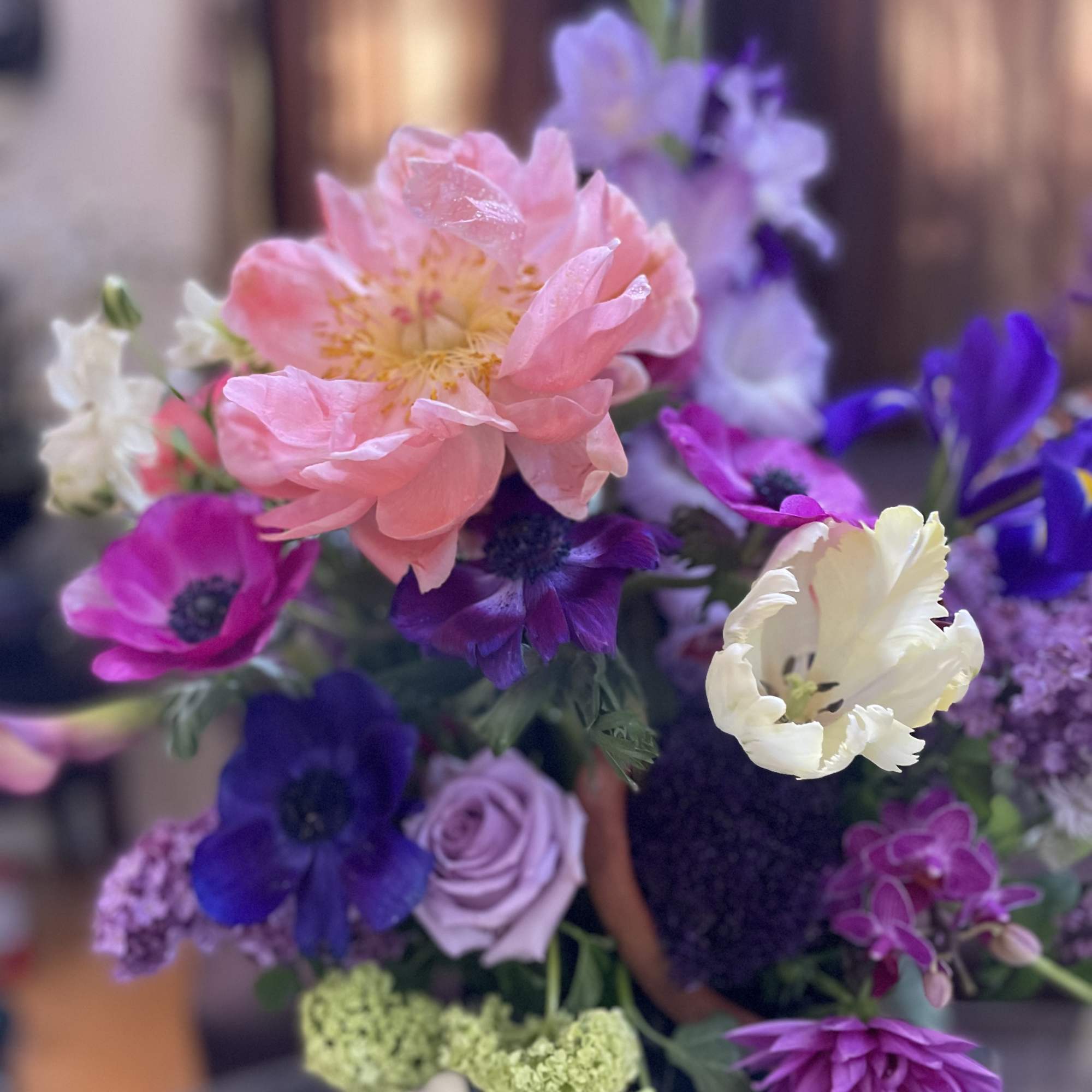 Bouquet of pink, purple, and white flowers with a large peach bloom