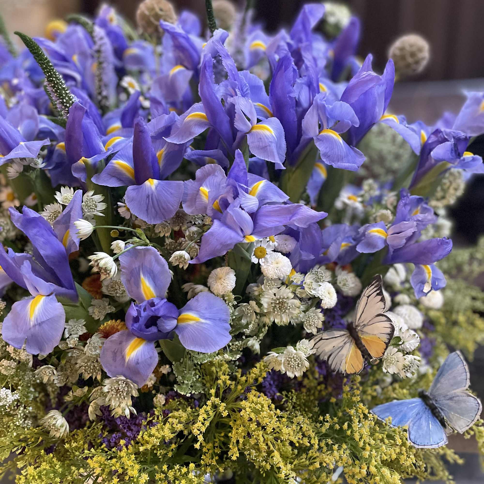 Purple iris bouquet with small white flowers and butterfly accents