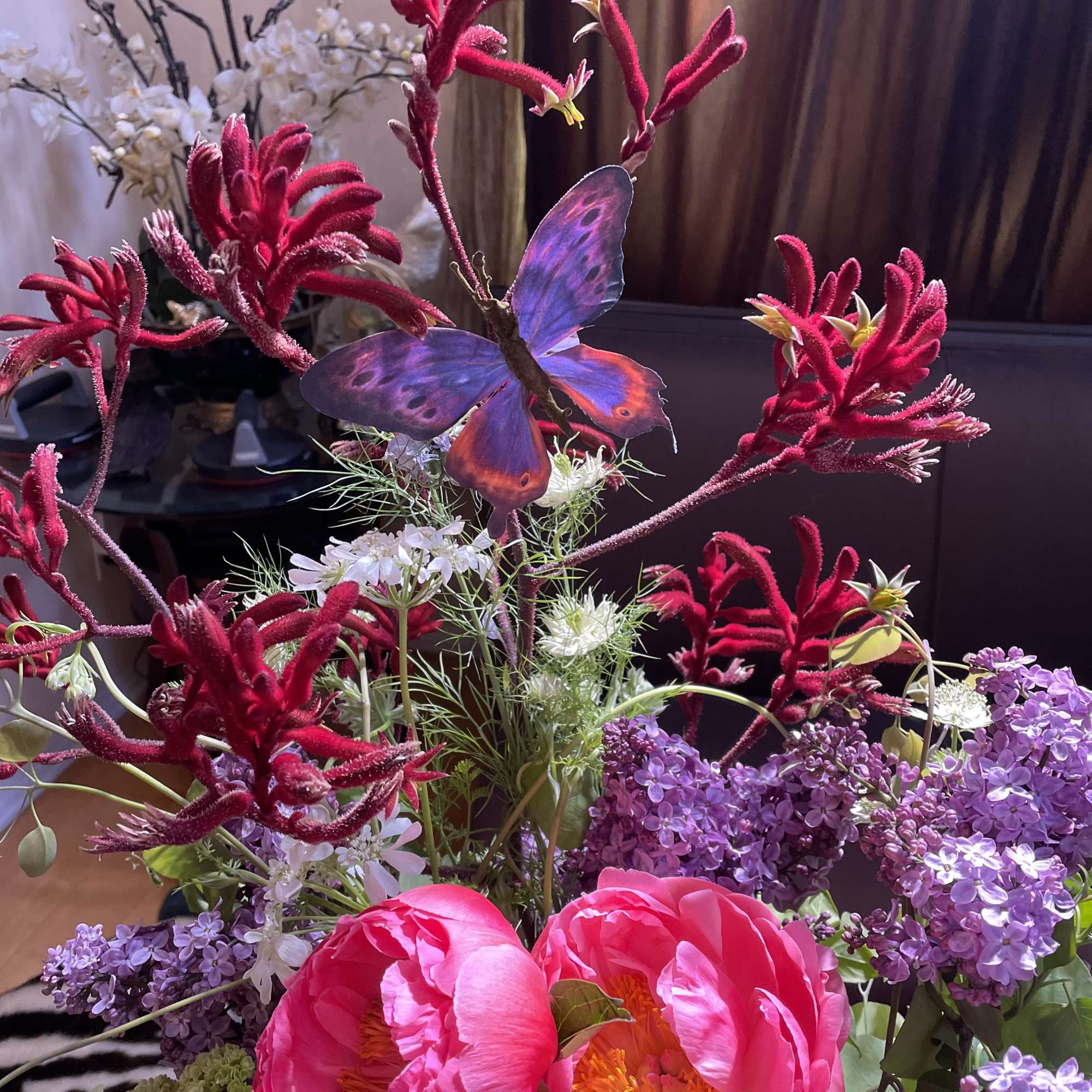 Bright pink peonies with purple lilacs and a butterfly decoration