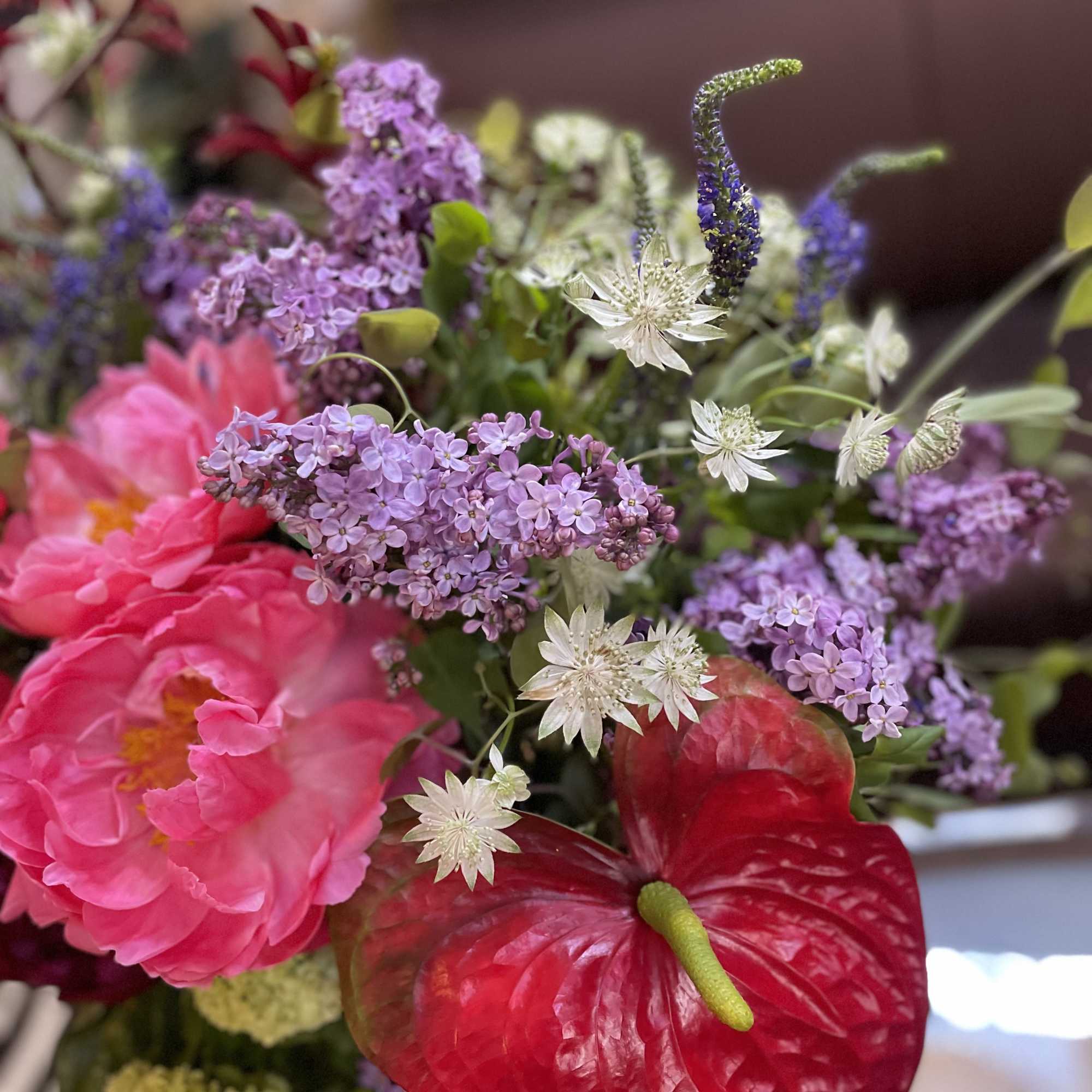 Bouquet with pink peonies, lilac clusters, and red anthurium flowers