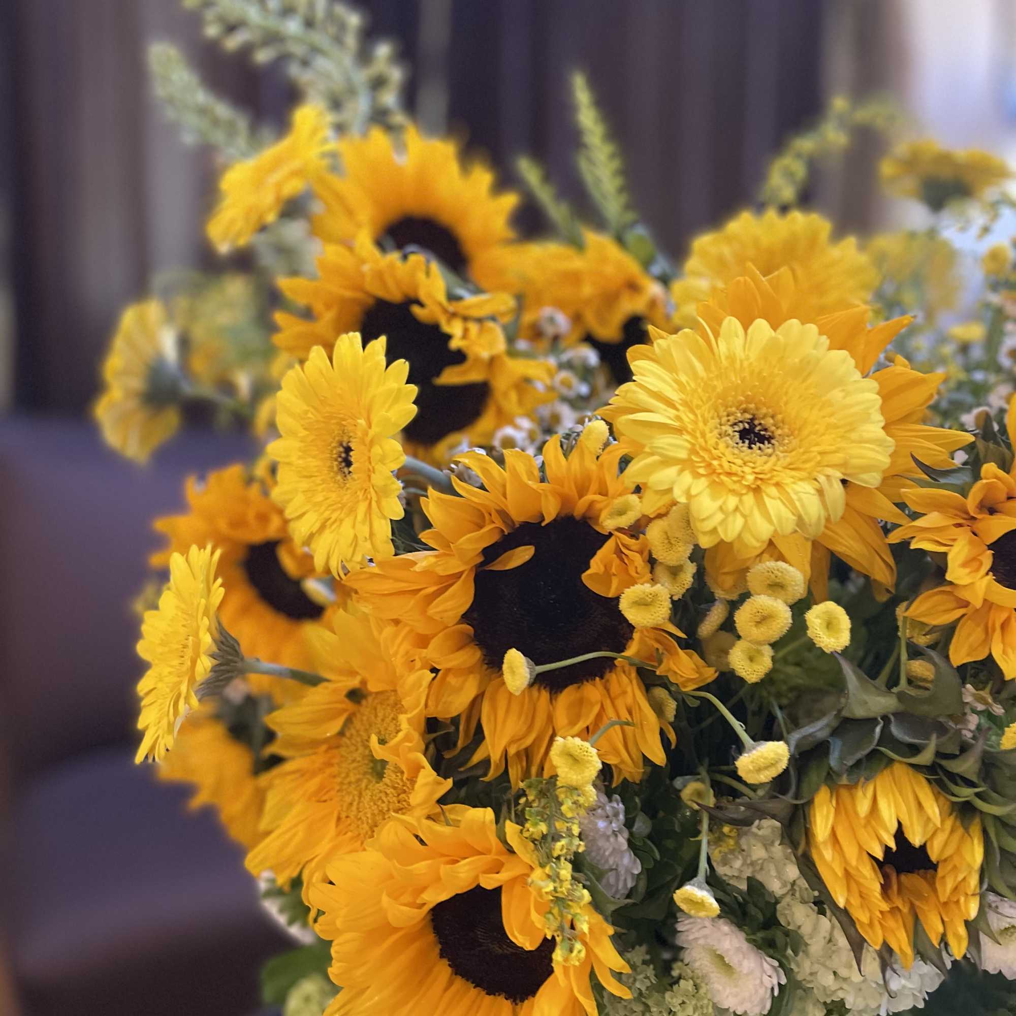 Bouquet of yellow sunflowers and daisies with white filler flowers