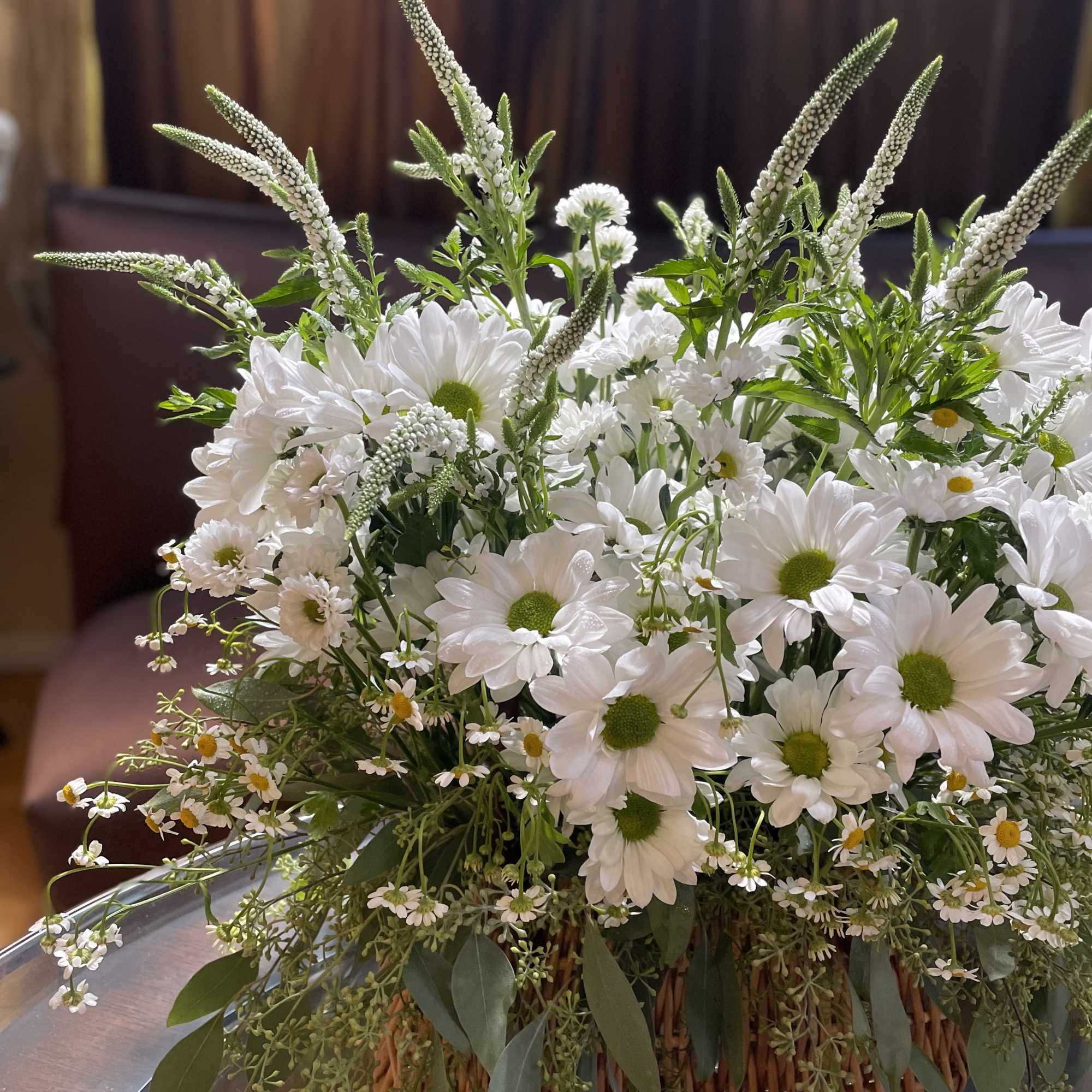 White daisy bouquet with tall white spikes in a woven basket