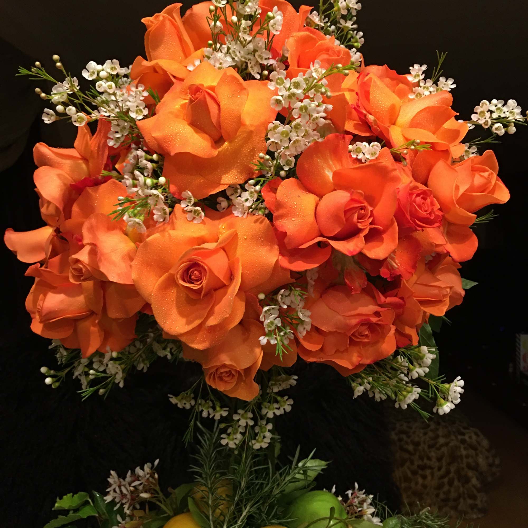 Orange rose bouquet with white filler flowers and citrus accents