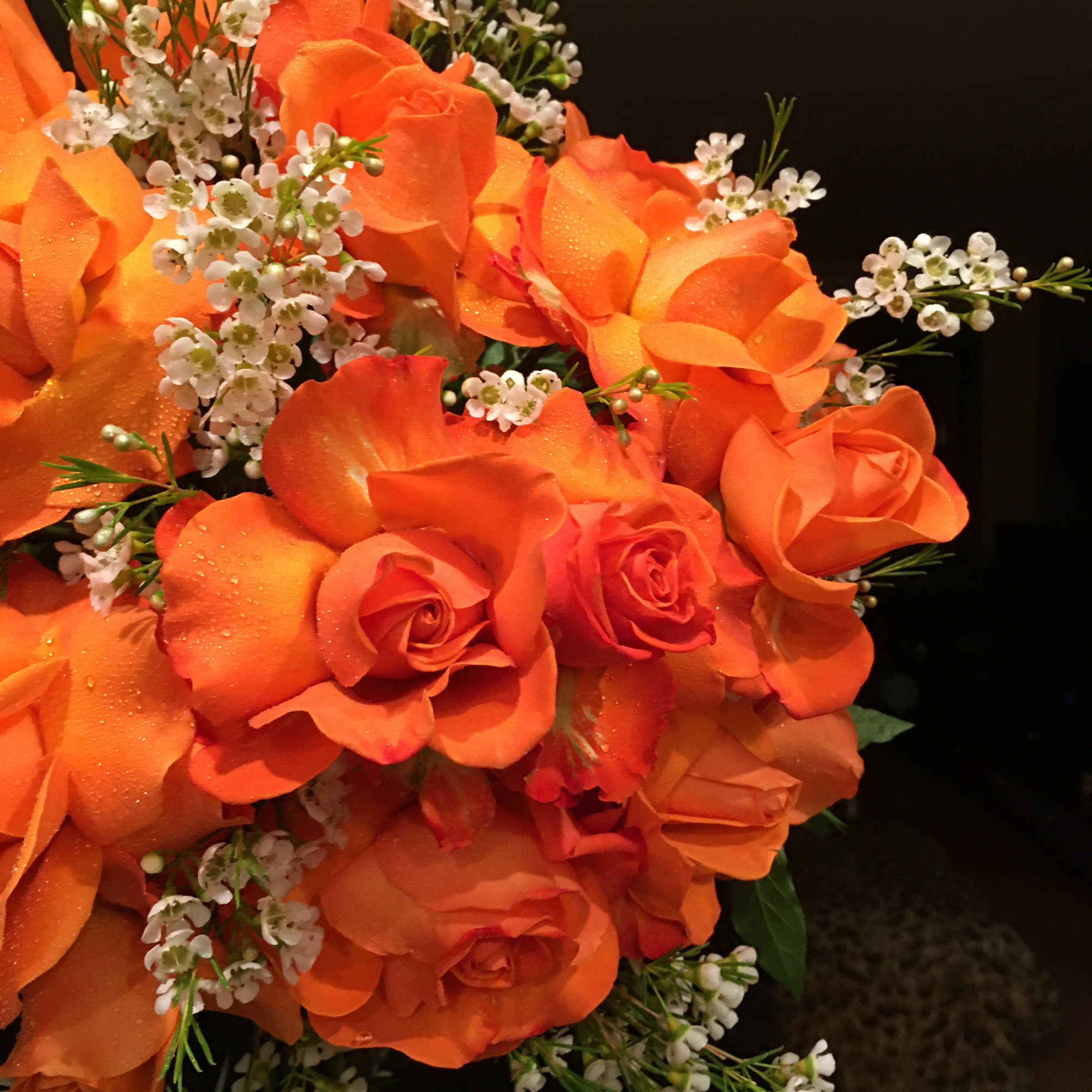 Orange rose bouquet with small white filler flowers