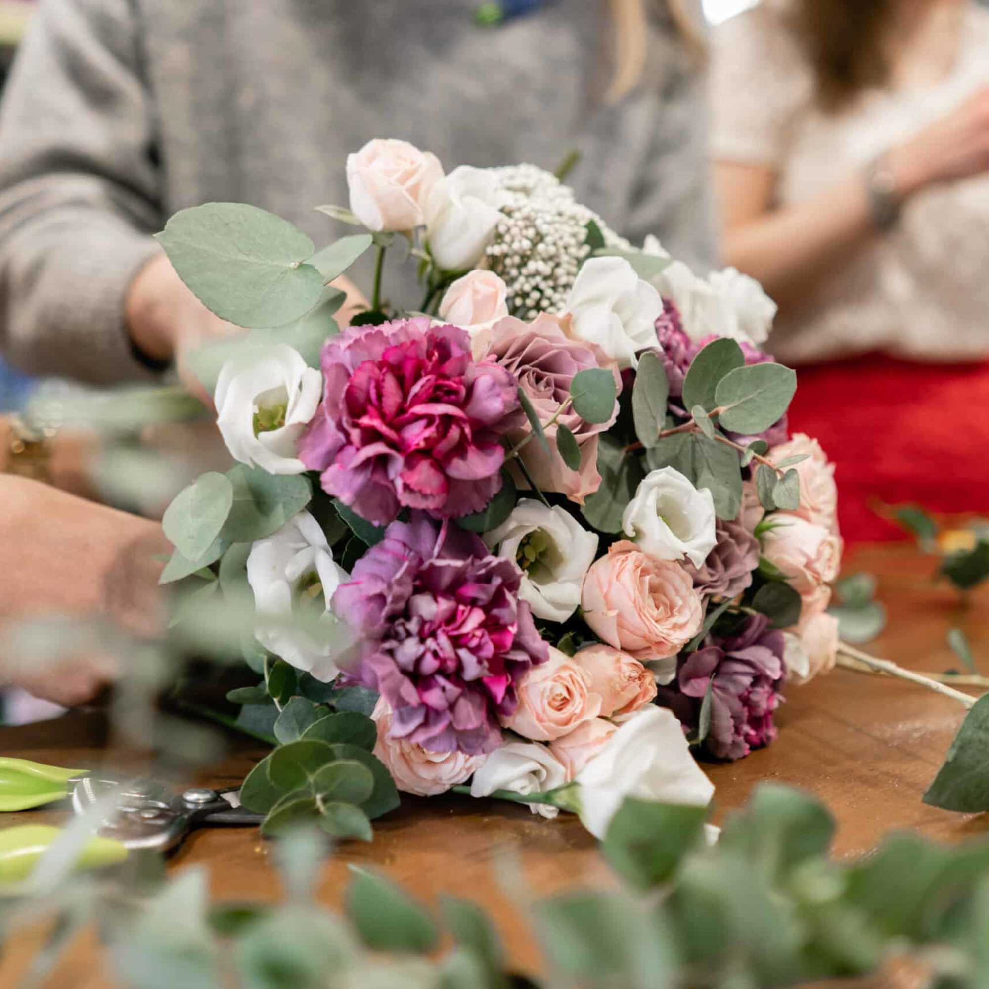 Hand-tied bouquet of pink, white, and purple flowers with eucalyptus