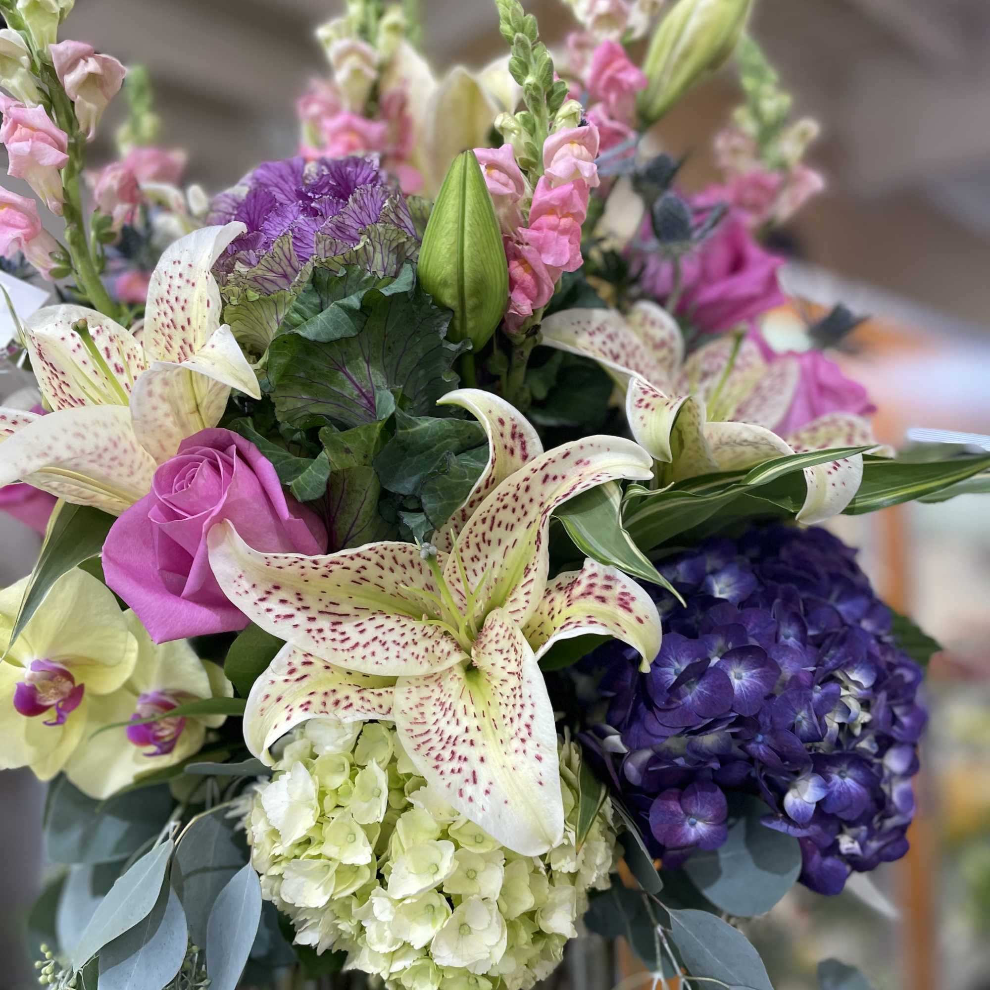Bouquet of lilies, roses, hydrangea, and snapdragons in pink, purple, and cream