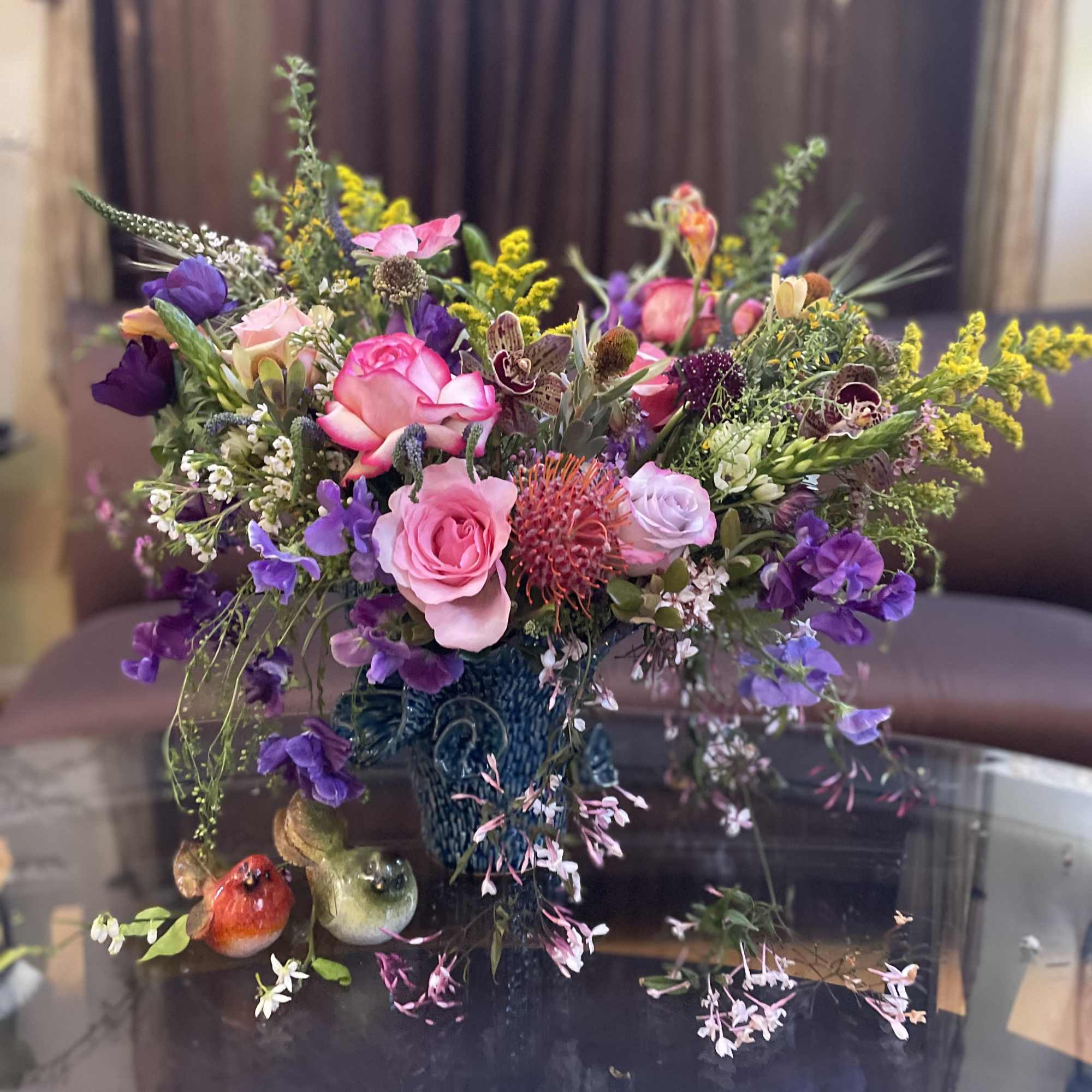 Mixed bouquet of pink, purple, and yellow flowers in a blue vase