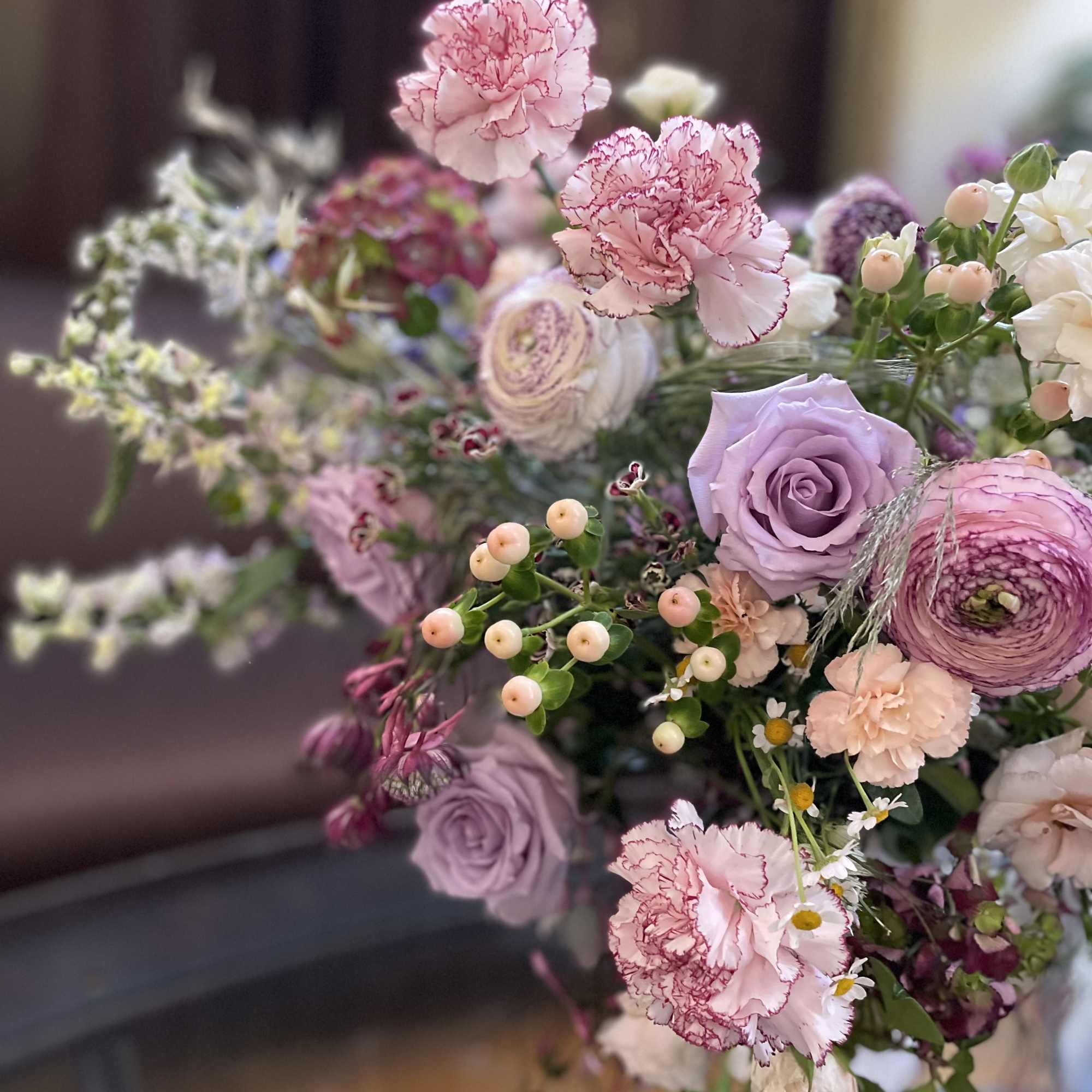 Bouquet of pink carnations, lavender roses, and mixed blooms