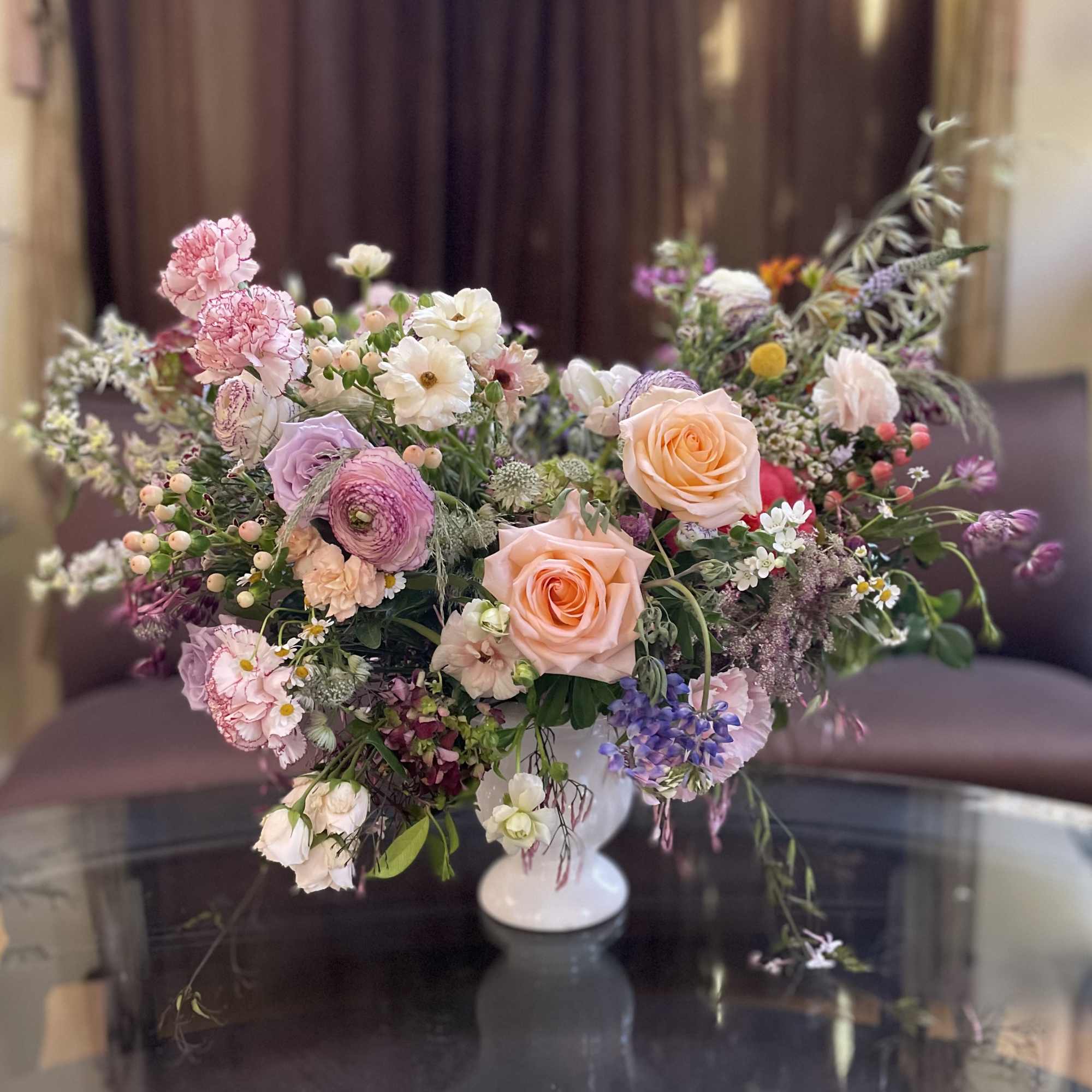 Mixed pastel flower arrangement in a white vase