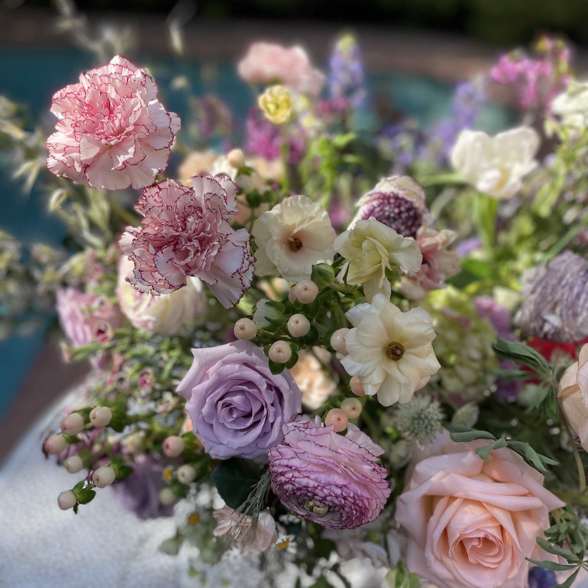 Pastel bouquet with pink carnations, lavender roses, and white blooms