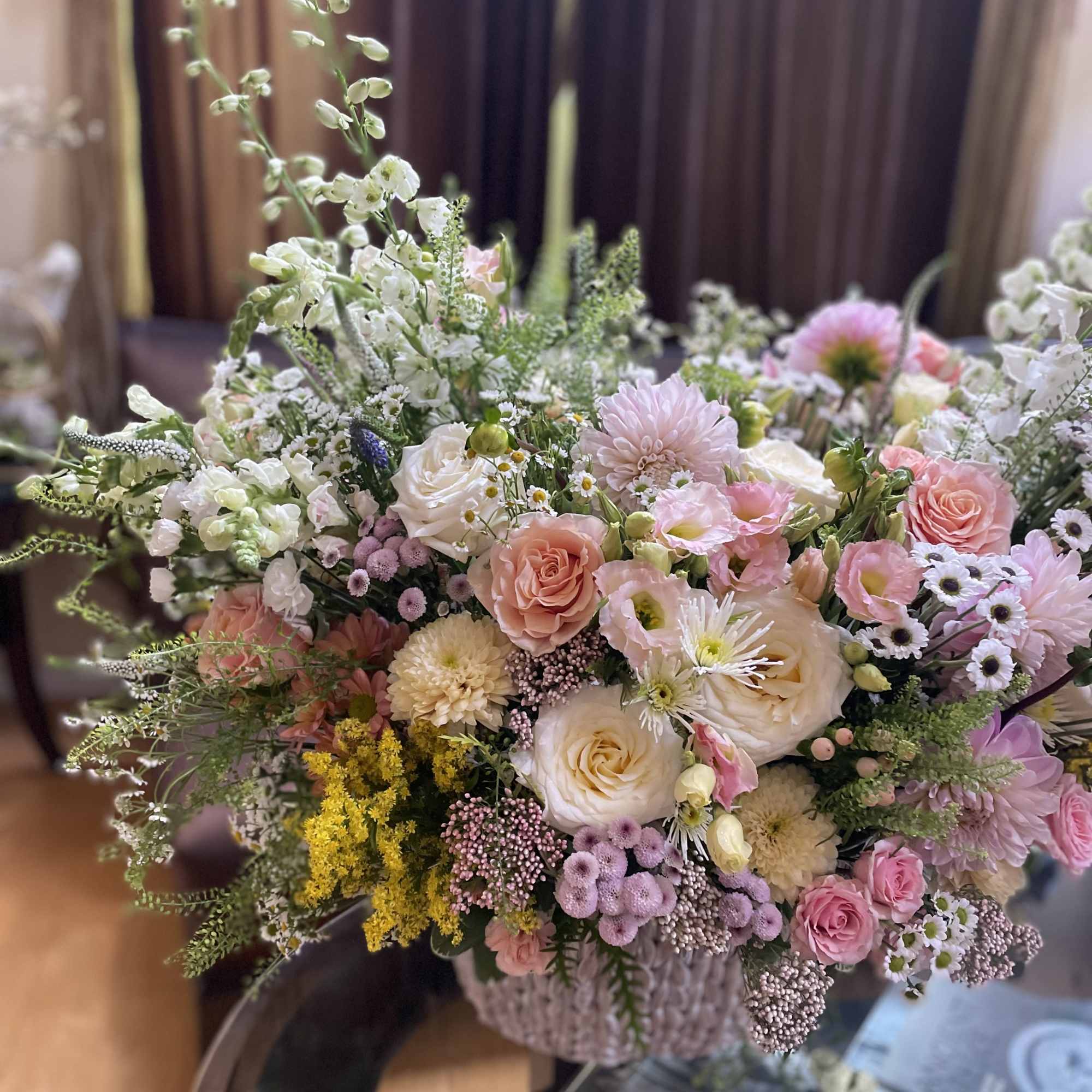 Large pastel bouquet with pink and white flowers in a woven basket