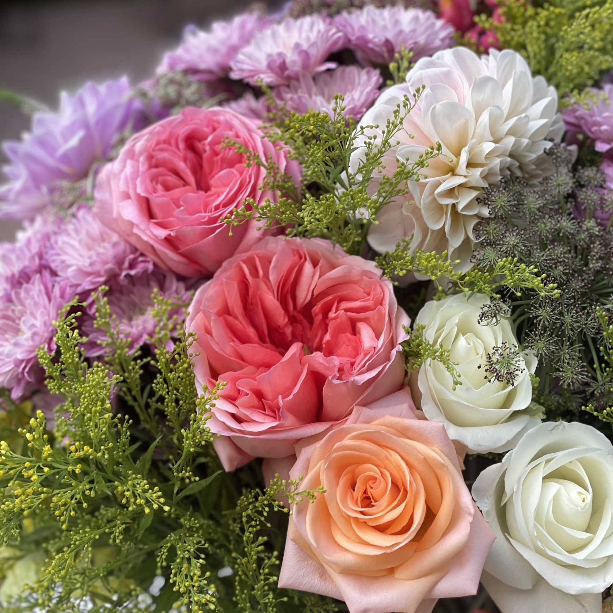 Bouquet of pink, peach, and white roses with lavender blooms