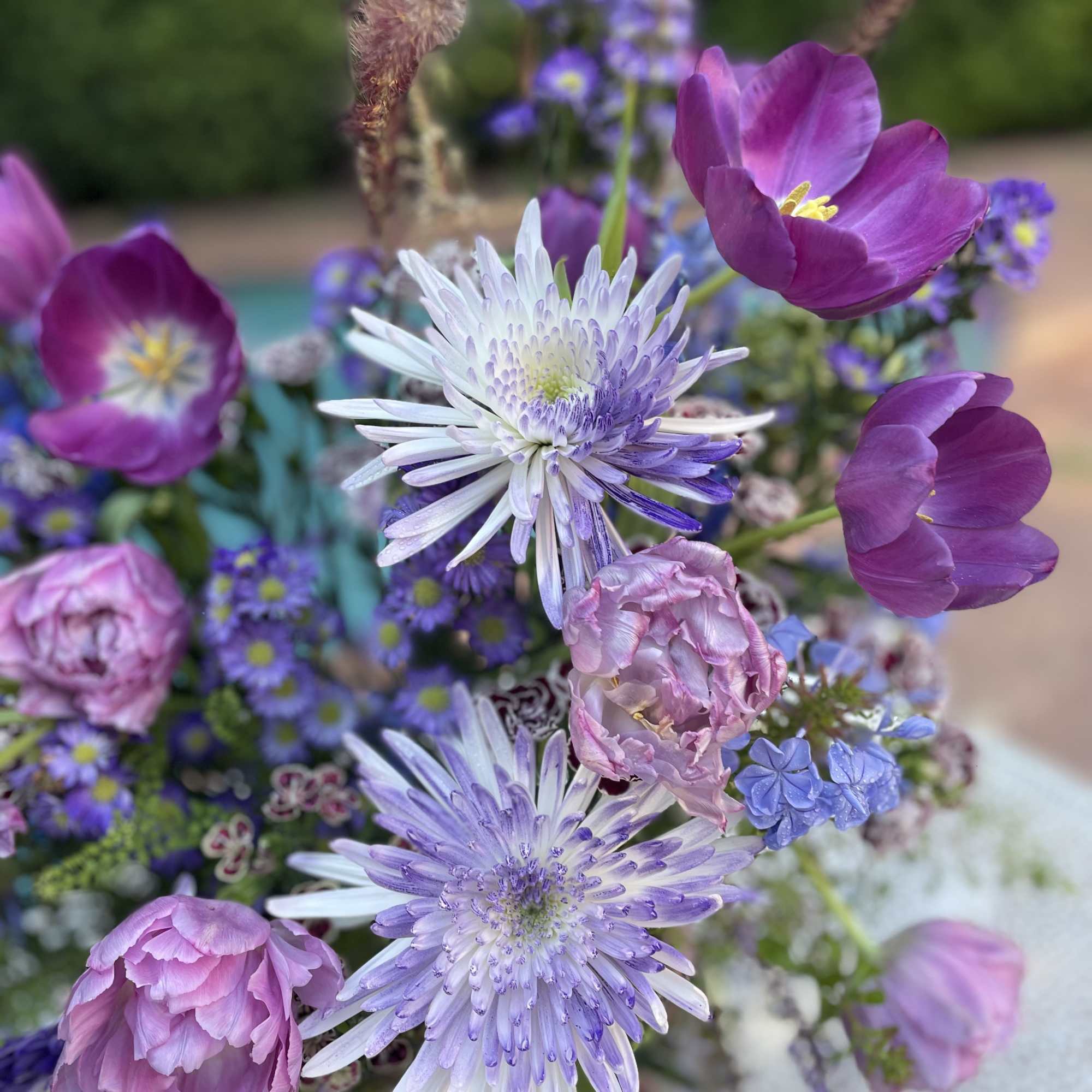 Purple and lavender bouquet with daisy-like blooms and tulip-shaped flowers