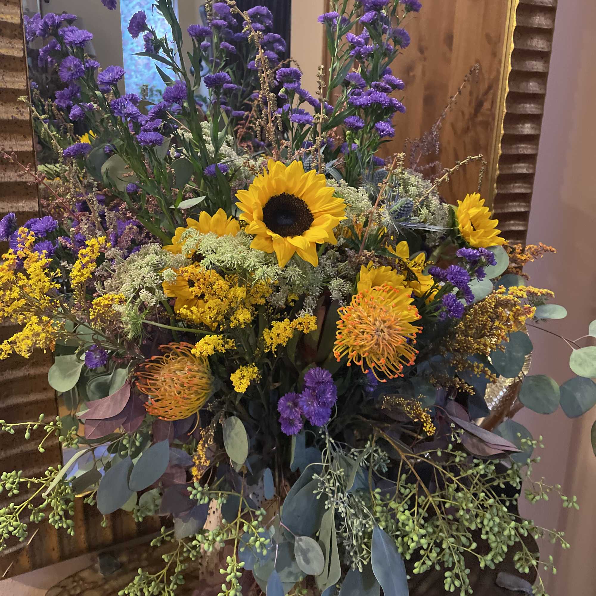 Tall bouquet with sunflowers, purple asters, and orange pincushion blooms