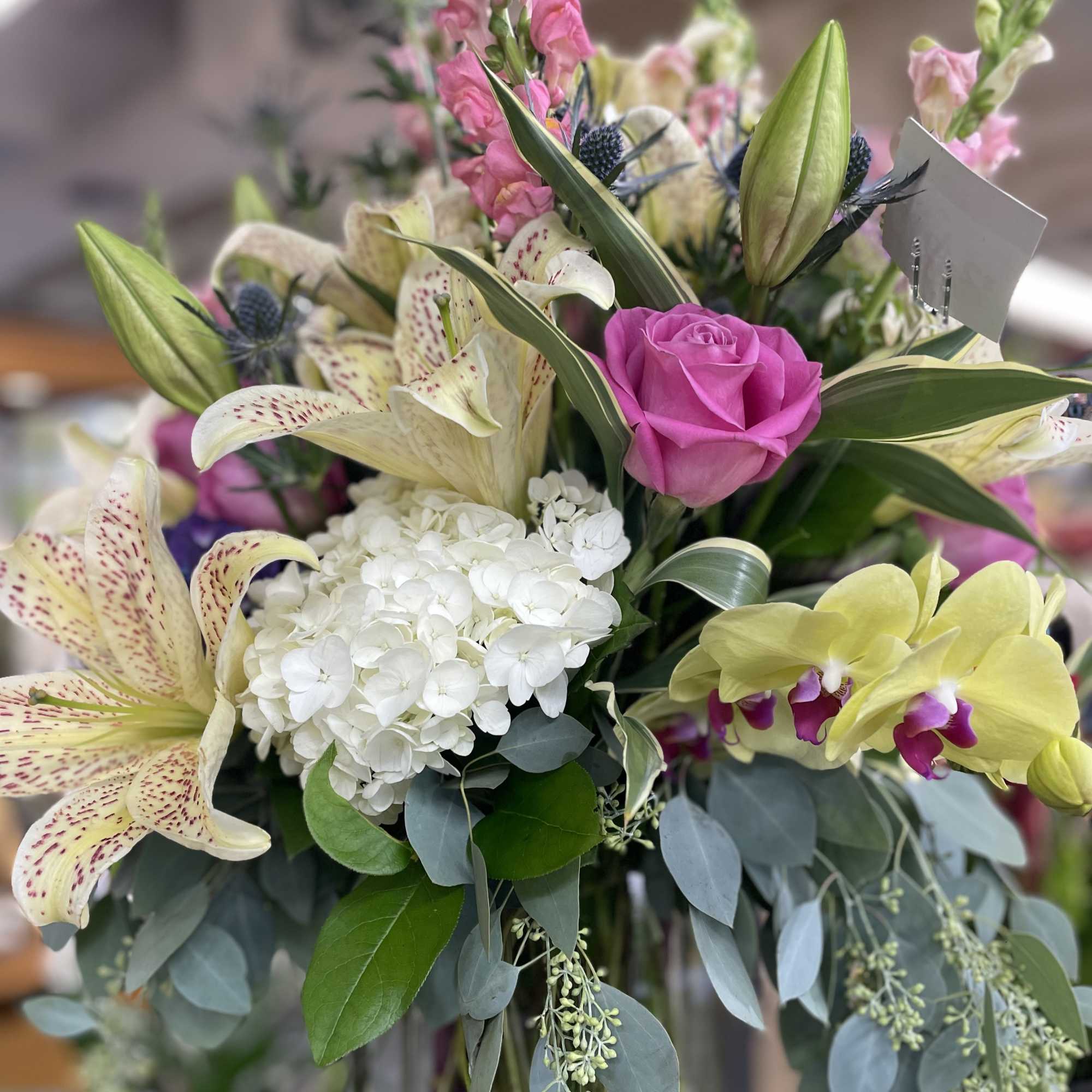 Bouquet with pink roses, white lilies, hydrangea, and orchids