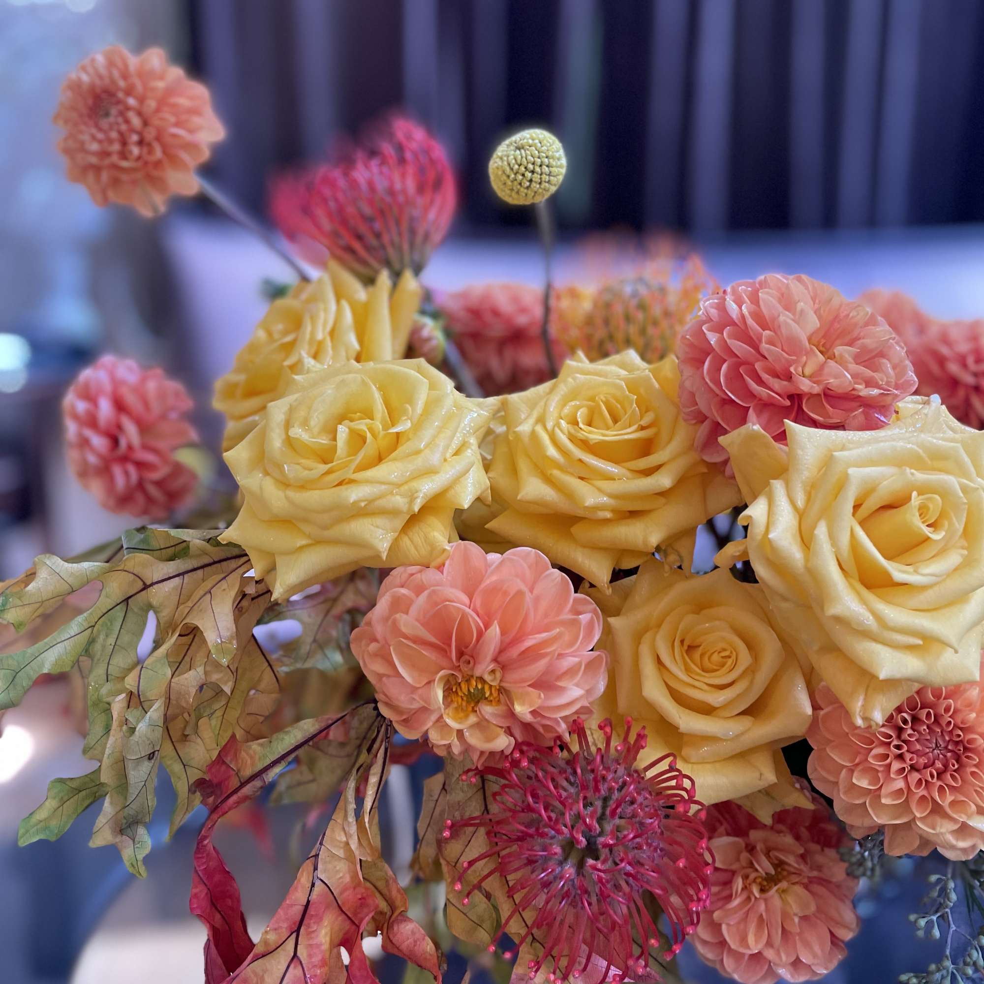 Bouquet of yellow roses and pink dahlias with autumn leaves