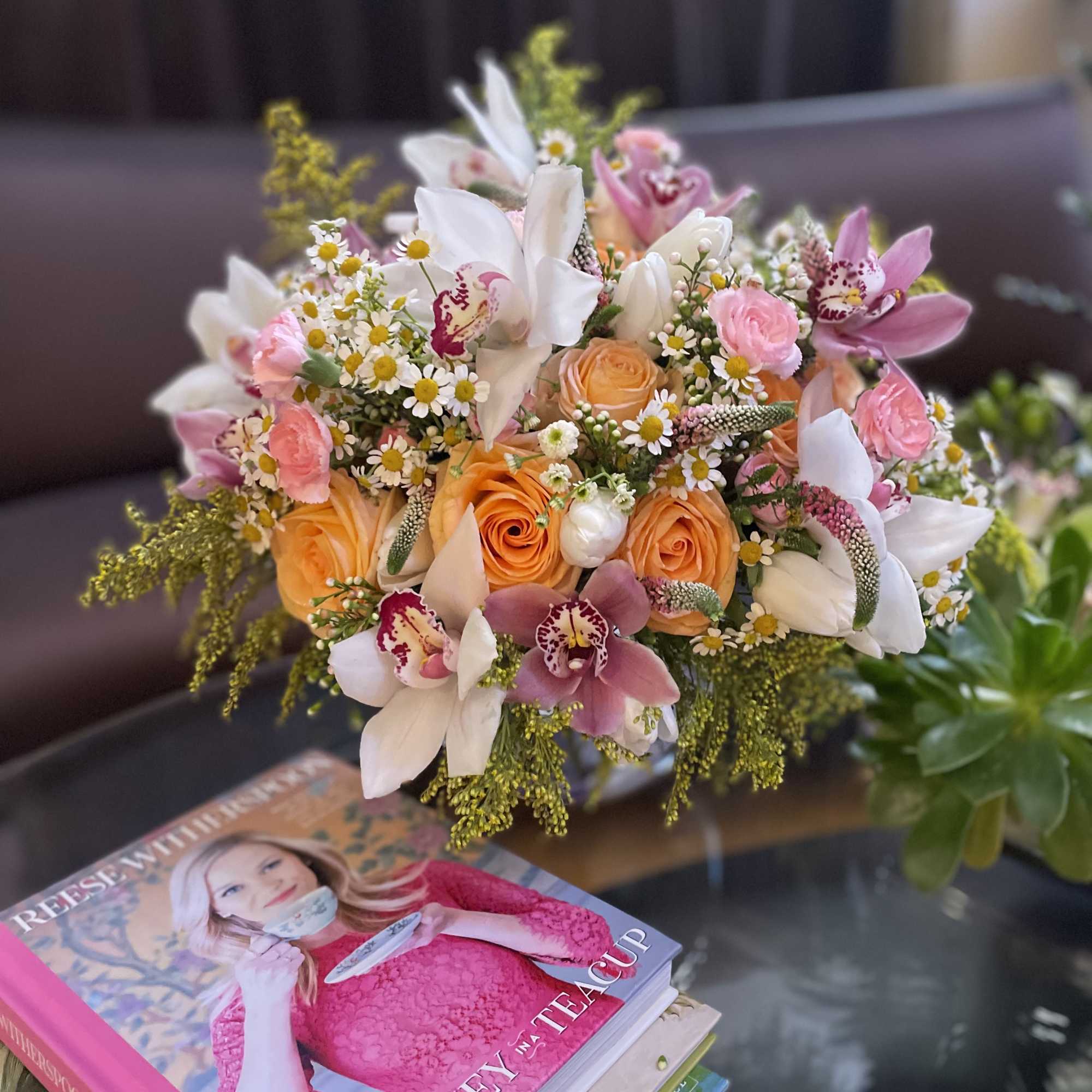 Bouquet of peach roses, white orchids, and small daisies
