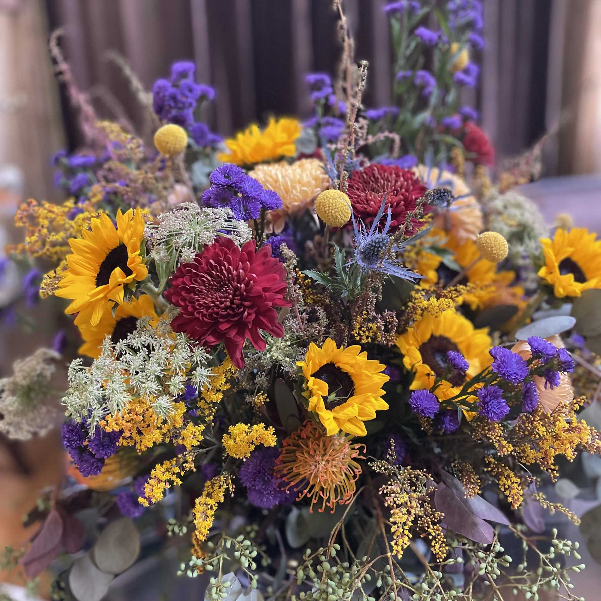 Mixed bouquet with sunflowers, purple blooms, and burgundy flowers