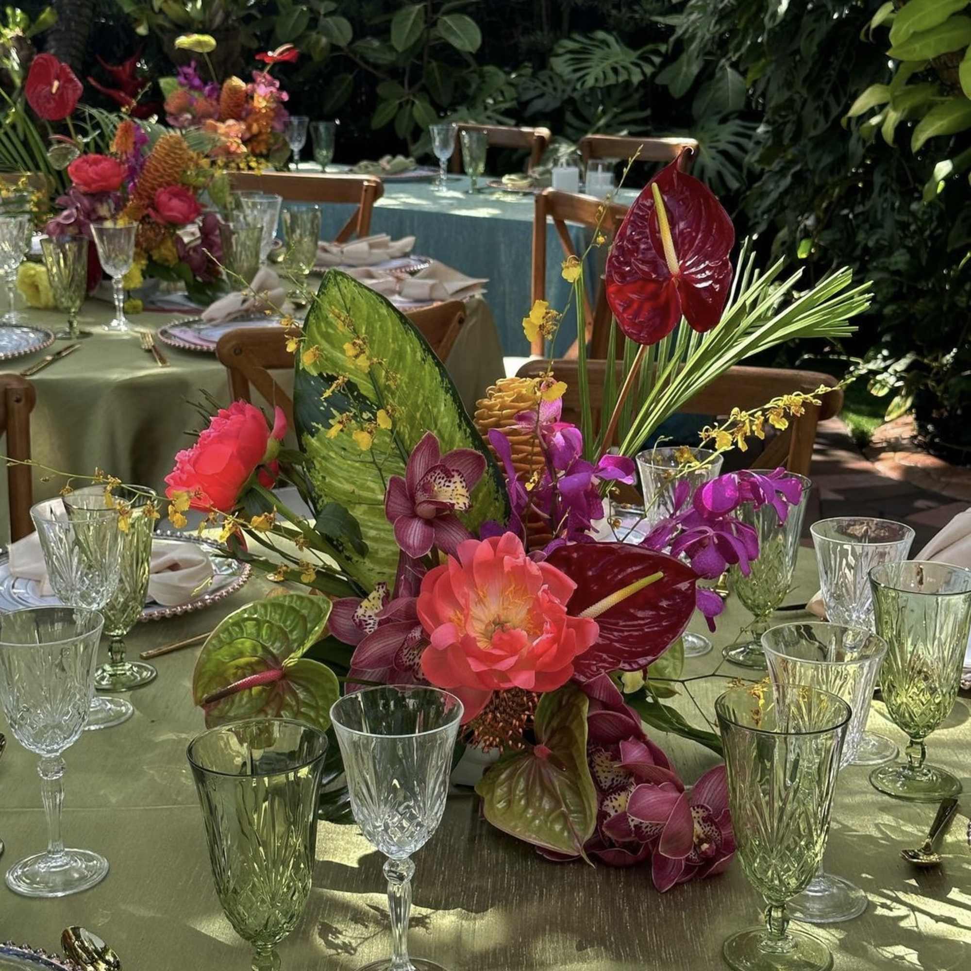 Tropical floral centerpiece with orchids and anthuriums on a banquet table