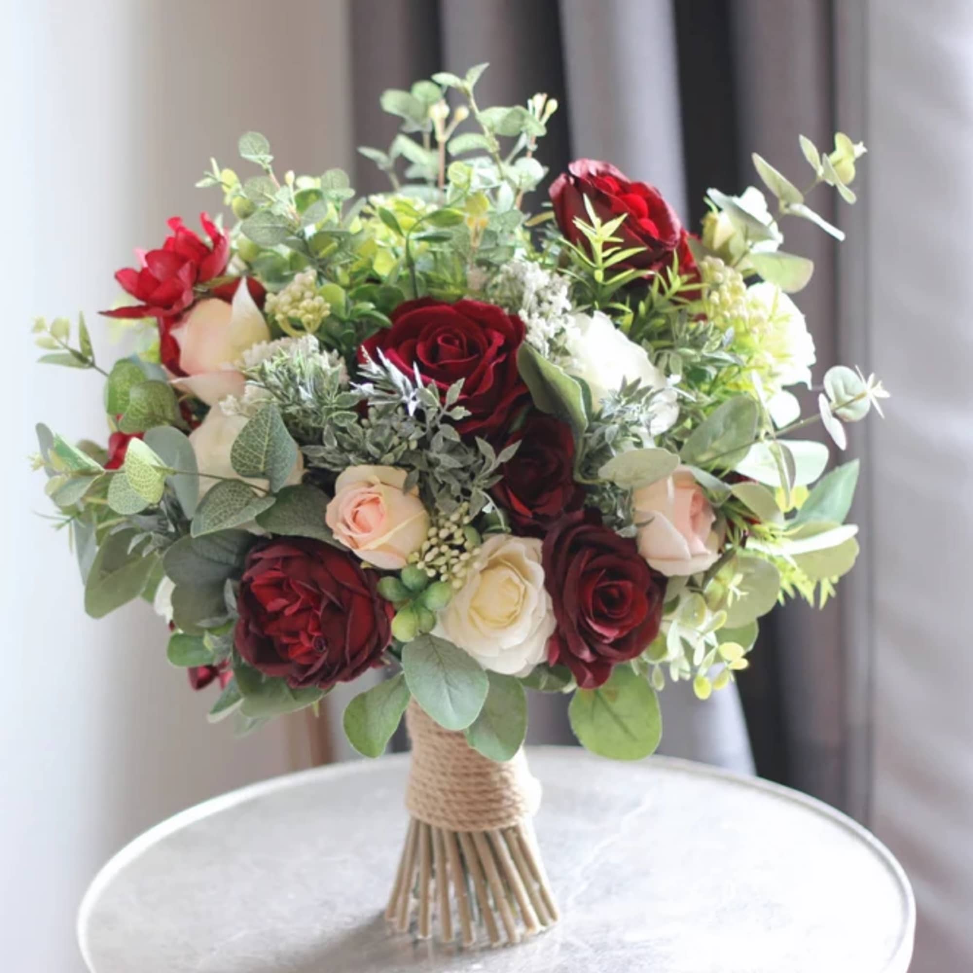 Bouquet of red, white, and blush roses with greenery