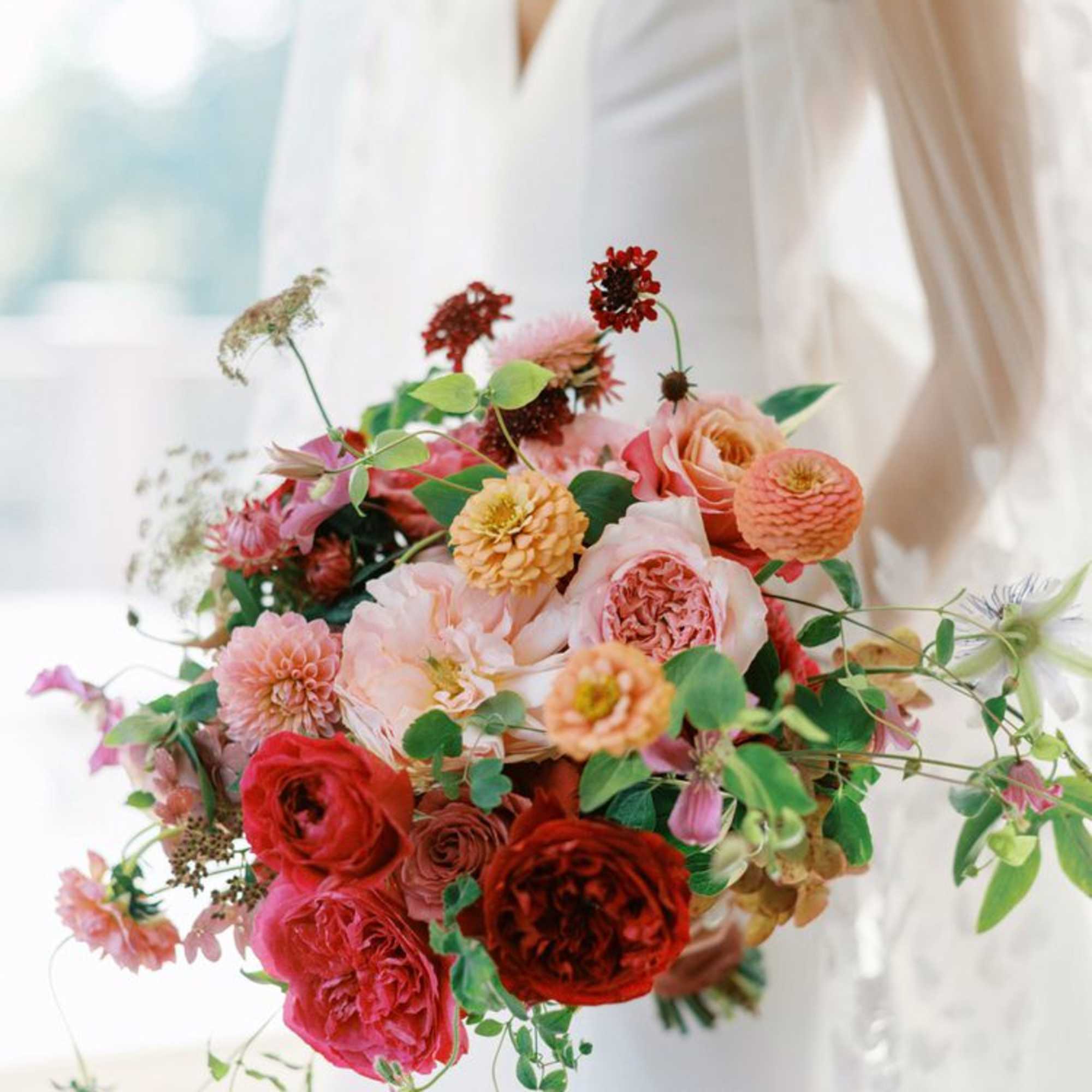 Bridal bouquet of pink, peach, and red flowers
