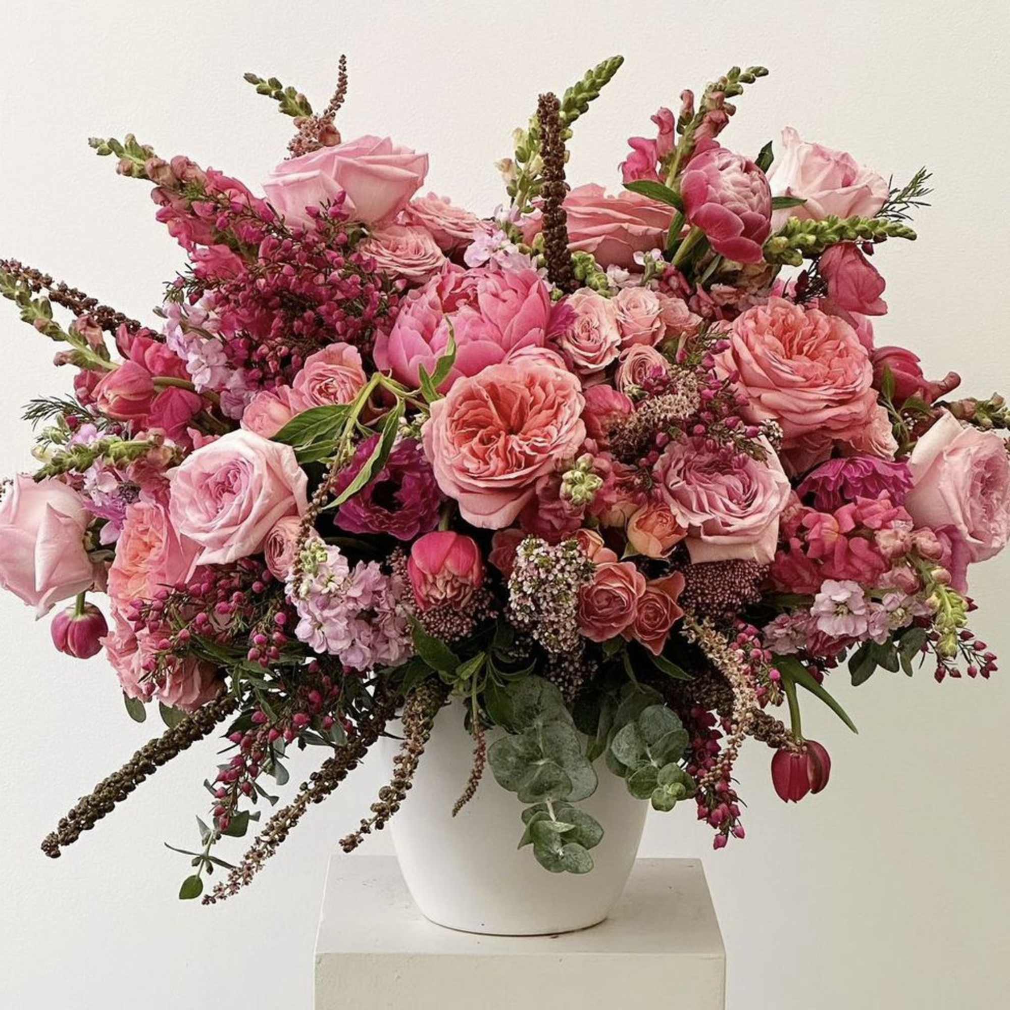 Pink floral arrangement in a white vase