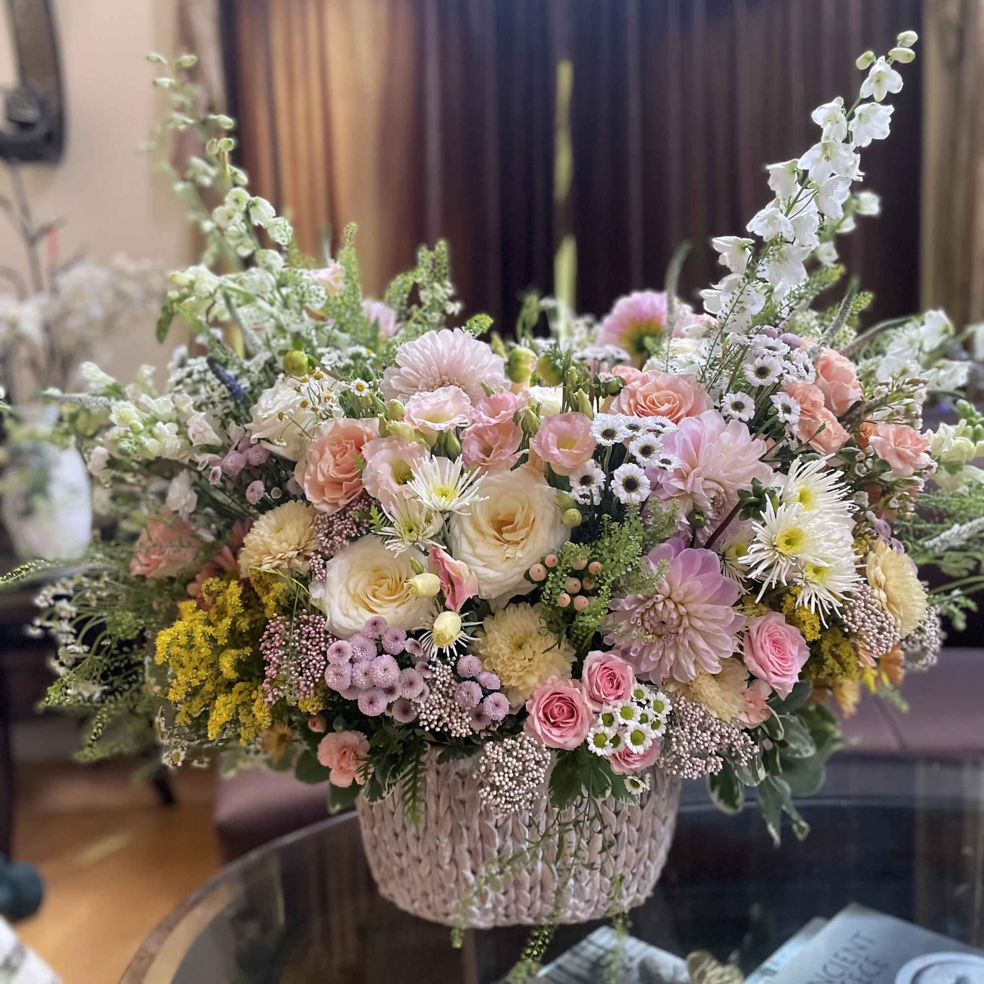 Large pastel flower arrangement in a woven basket