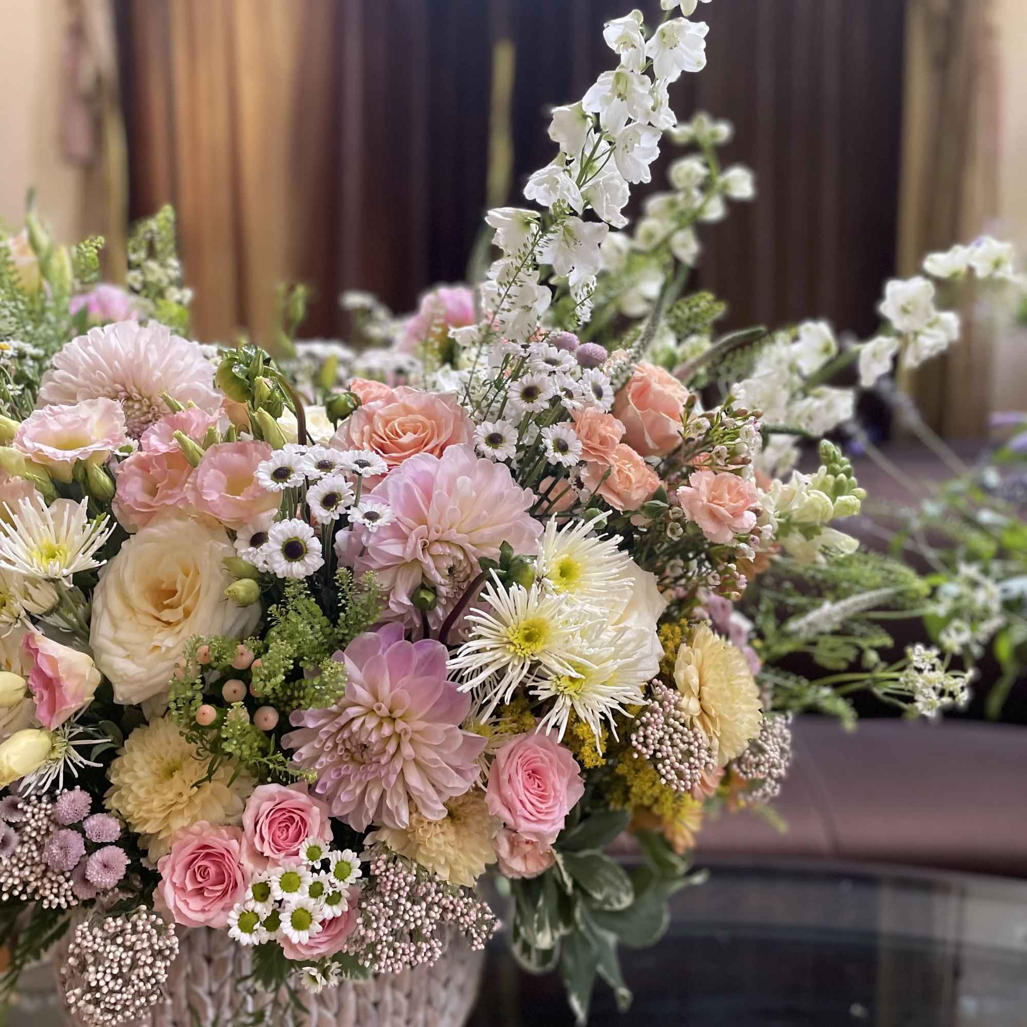 Pastel mixed flower arrangement in a woven basket