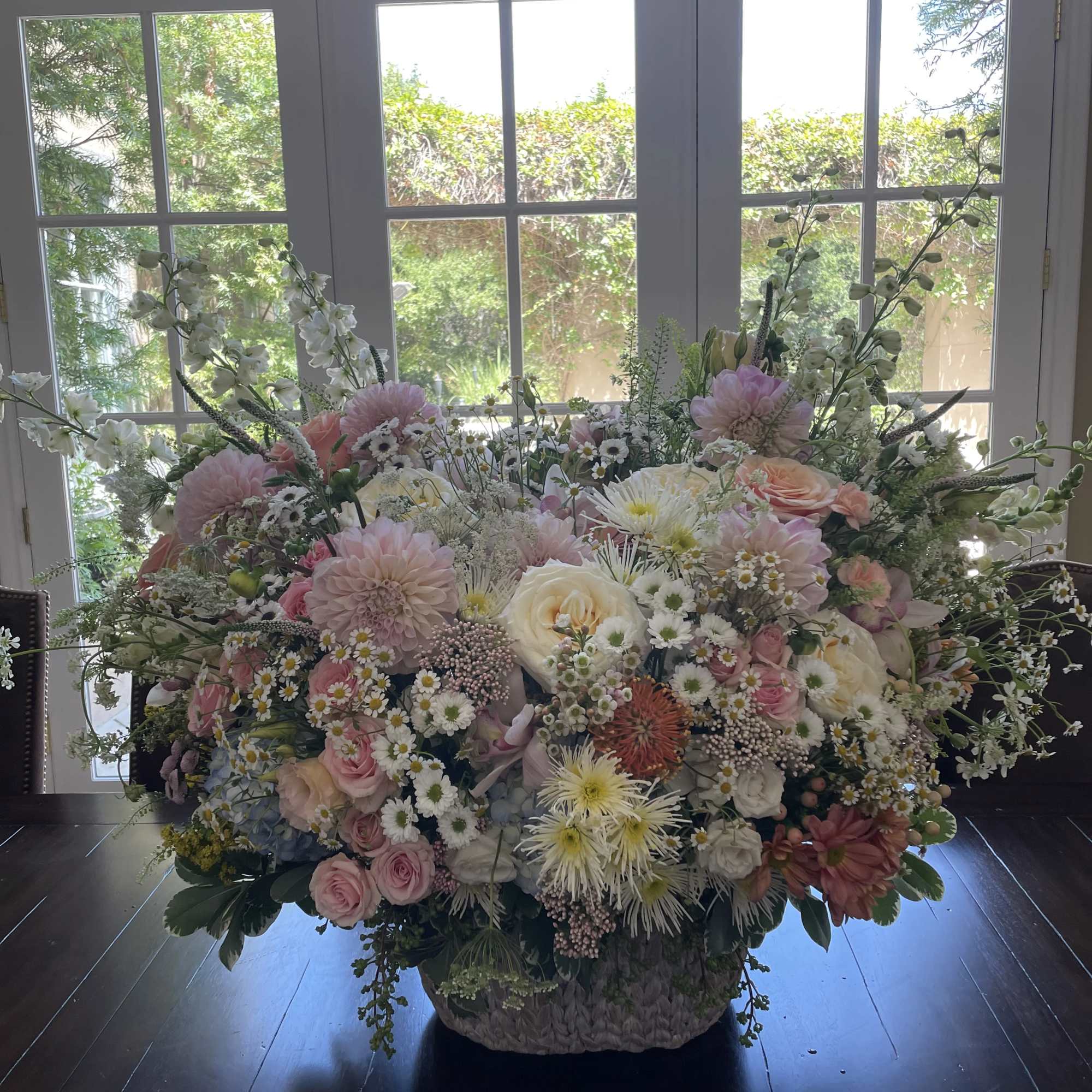 Large pastel floral arrangement in a woven basket