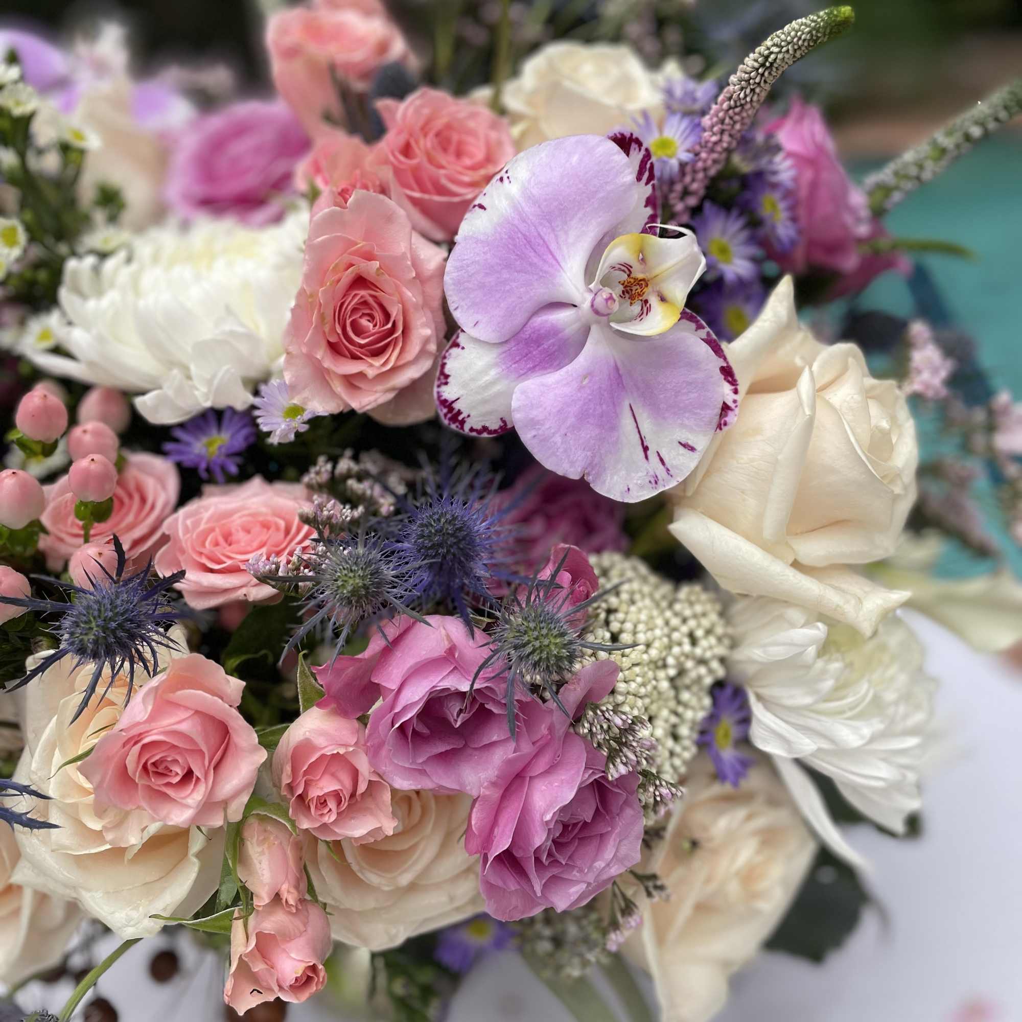 Bouquet of pink and white roses with a purple orchid